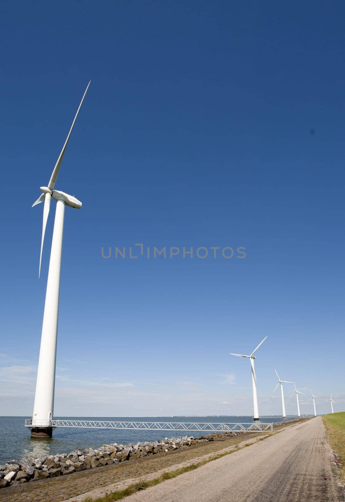 Wind turbines along the dike in the IJsselmeer in Flevoland, the Netherlands