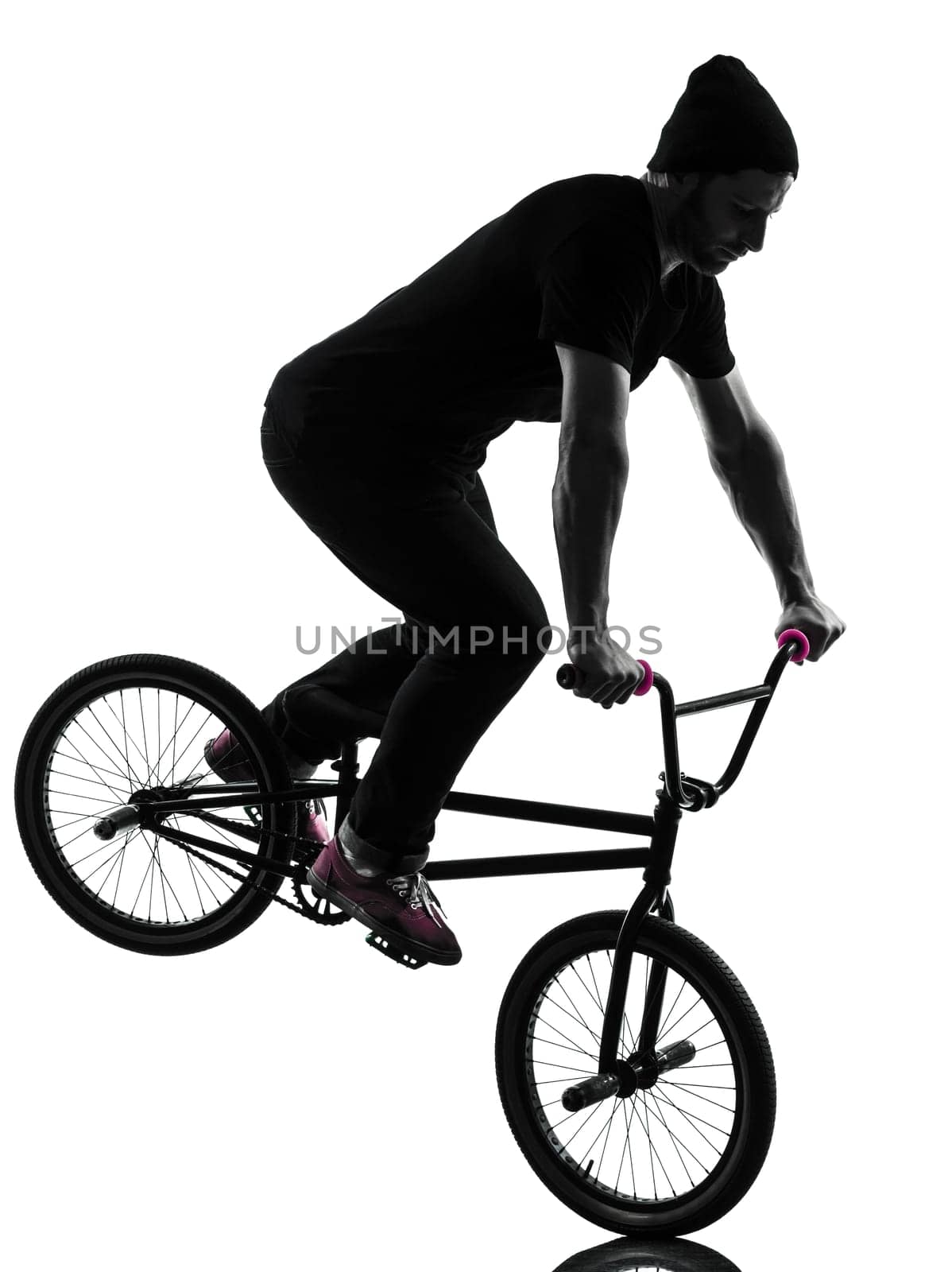 one caucasian man exercising bmx acrobatic figure in silhouette studio isolated on white background