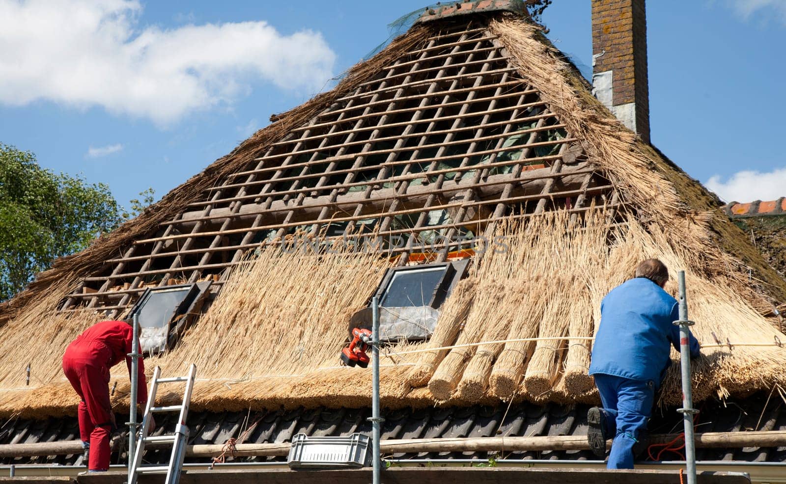 Workmen thatching a new roof