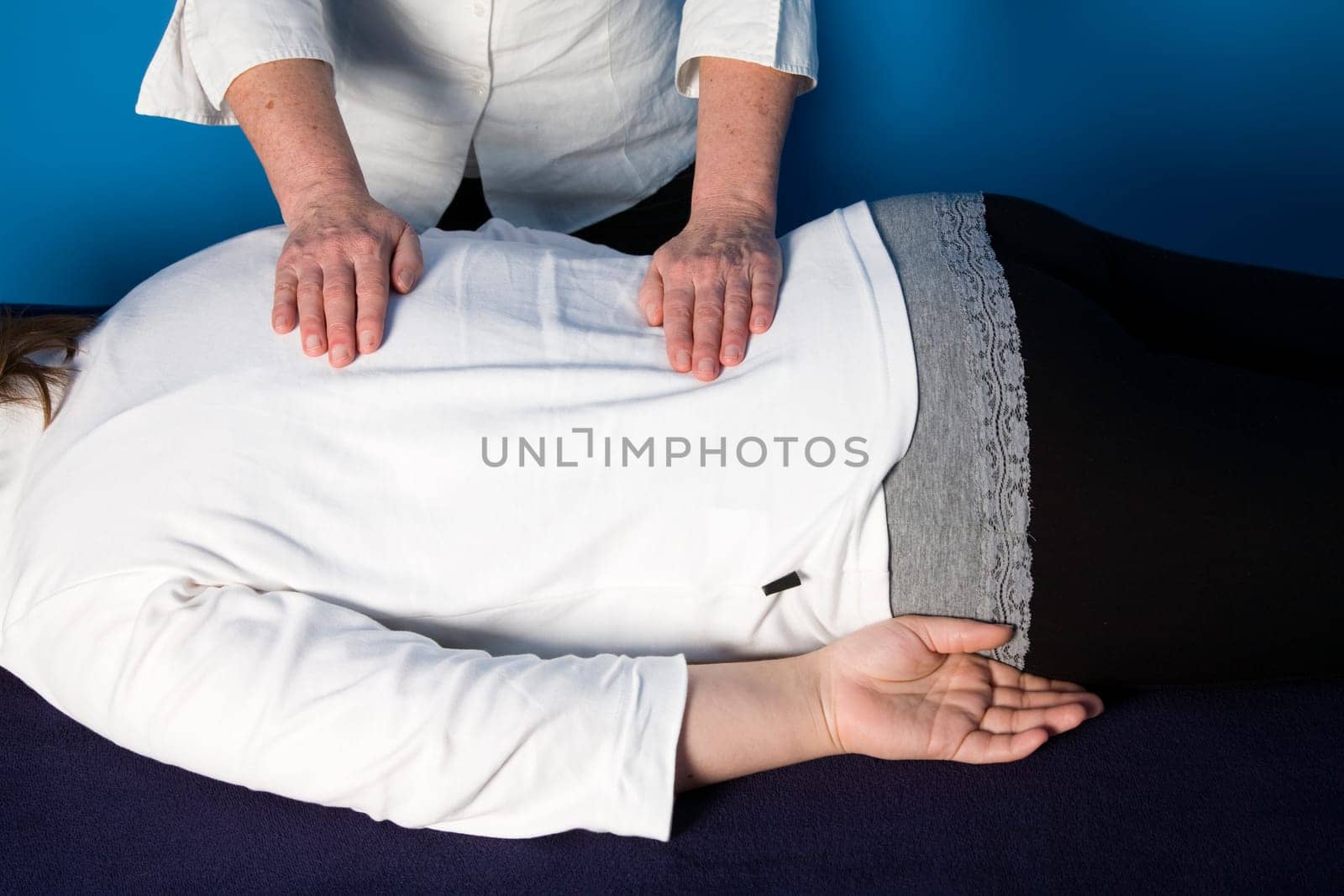 A young woman is getting a reiki treatment