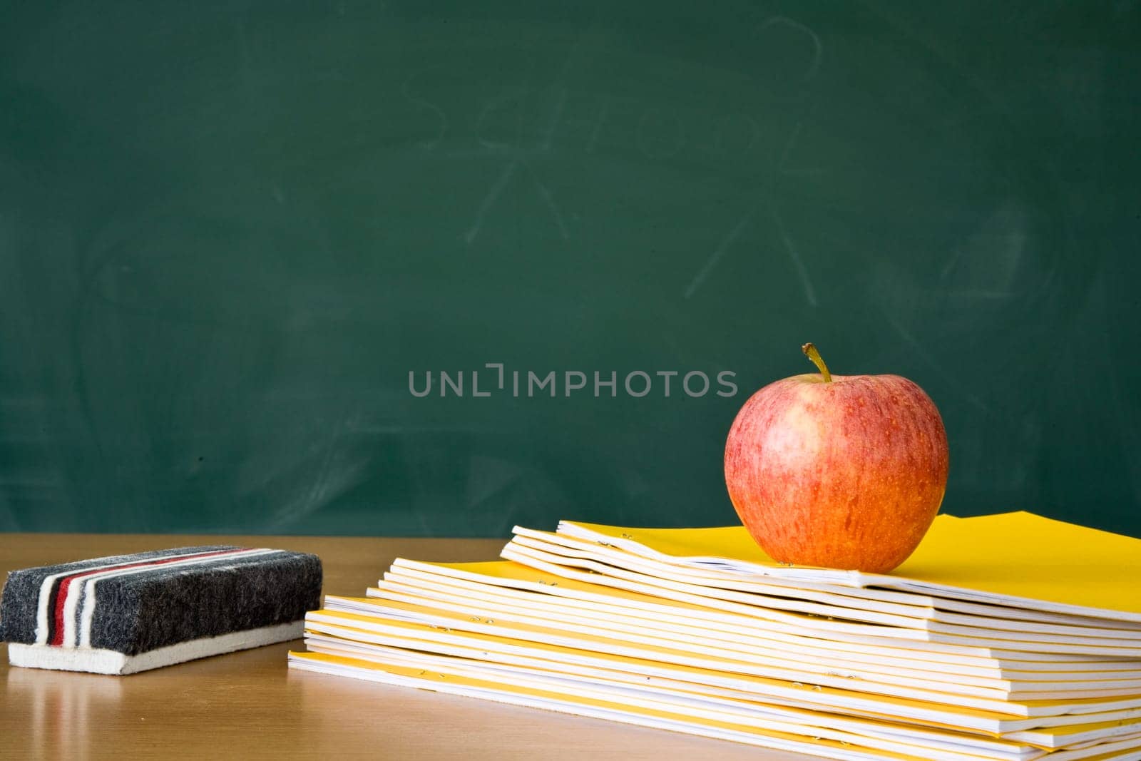 Still life of a teachers desk with a blackboard in the background