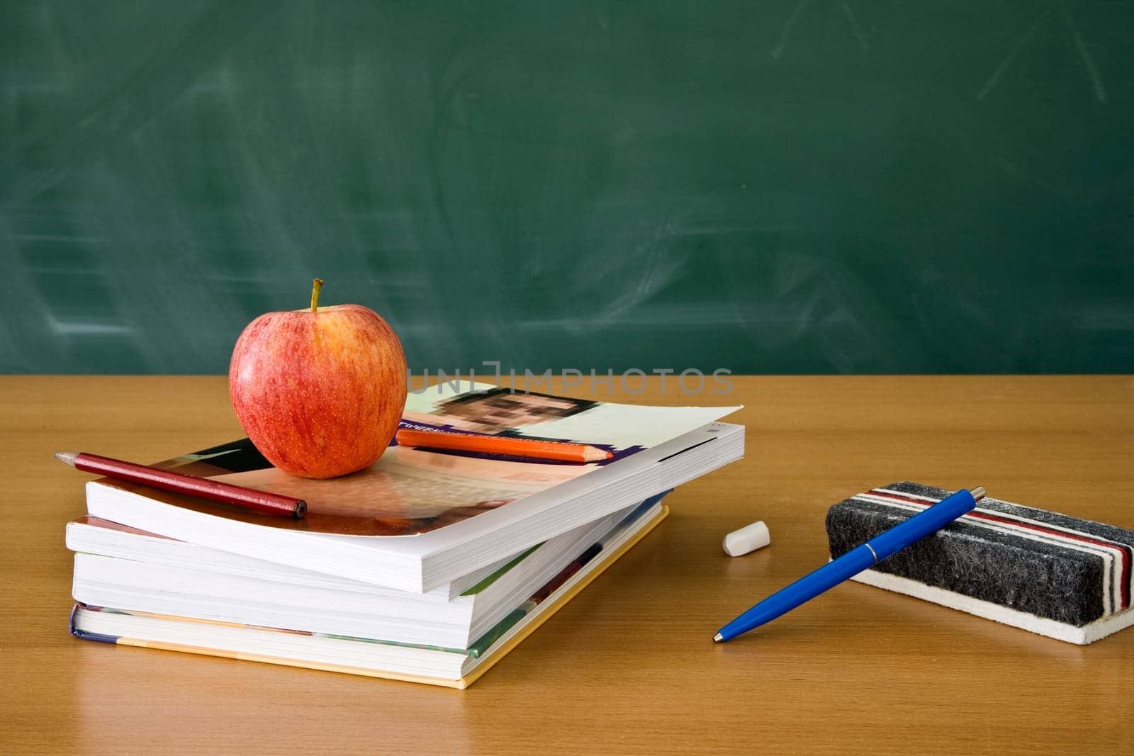 Still life of a teachers desk with a blackboard in the background