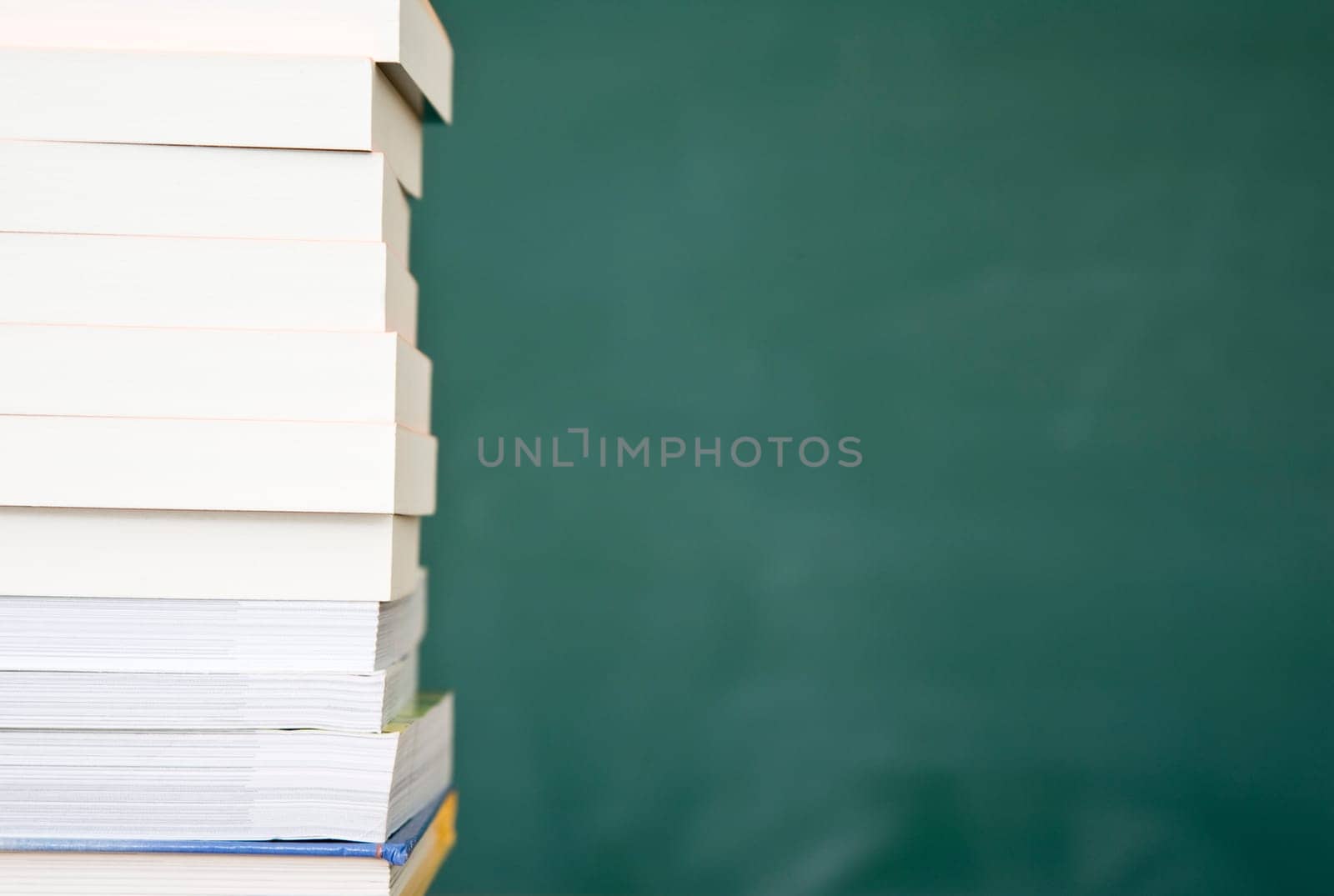 Books with used green chalkboard in the background