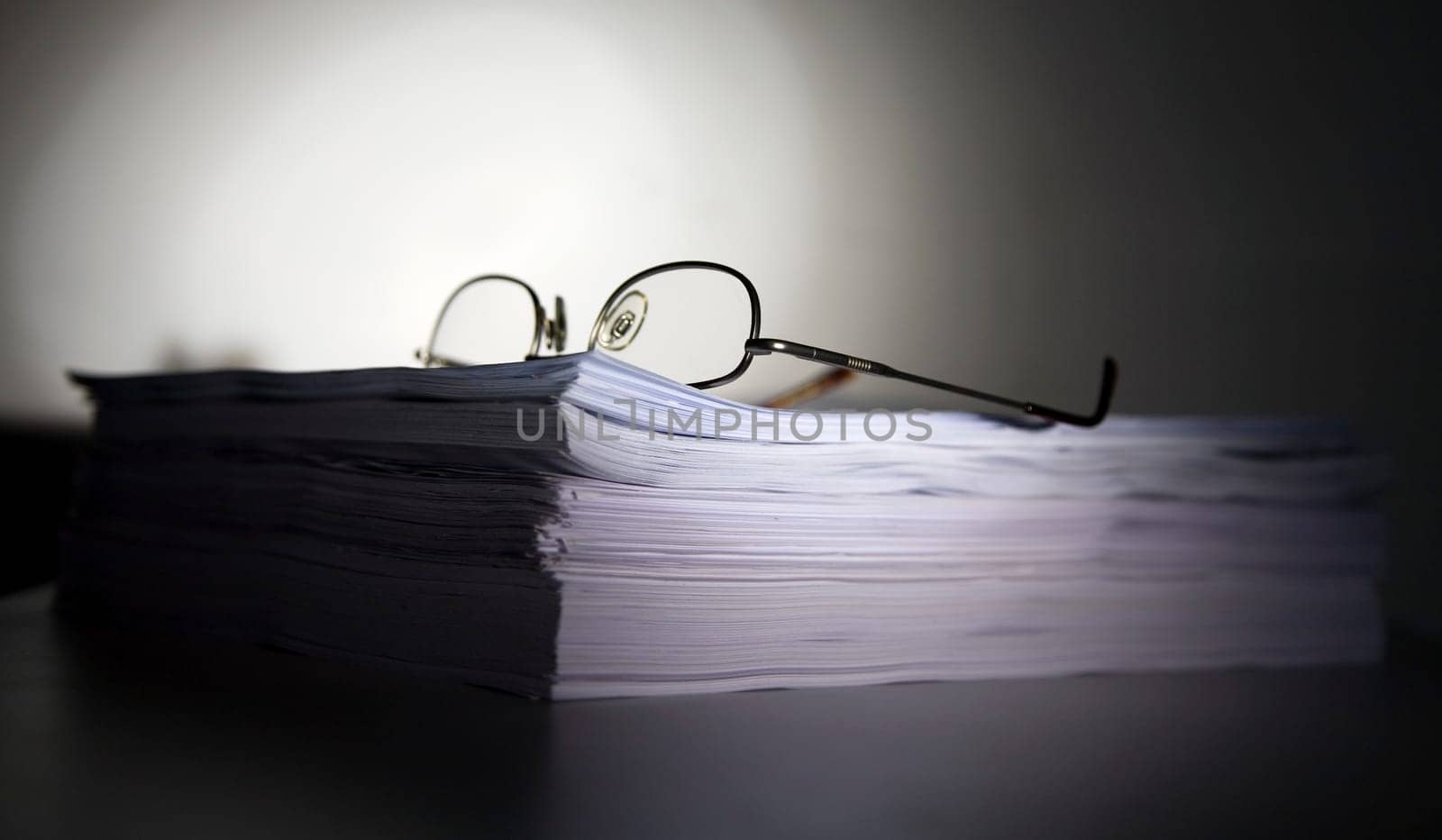 Pile of files with glasses