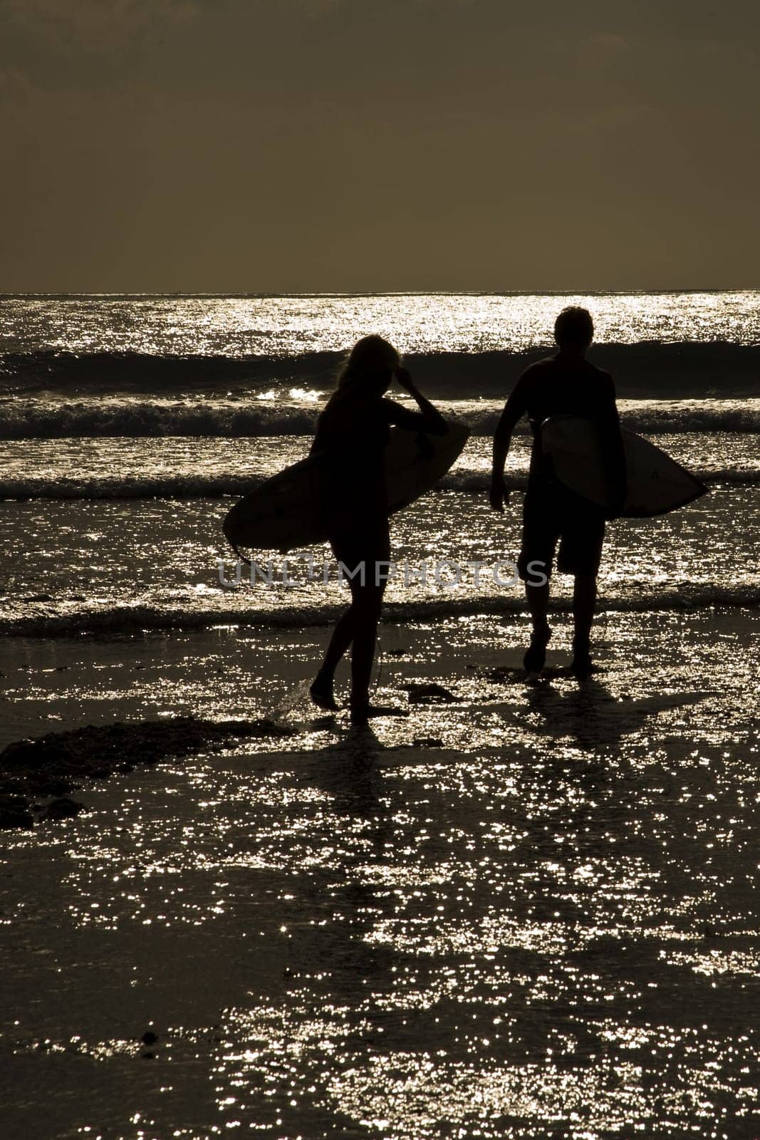 Surfers sunset at Uluwatu beach, Bali