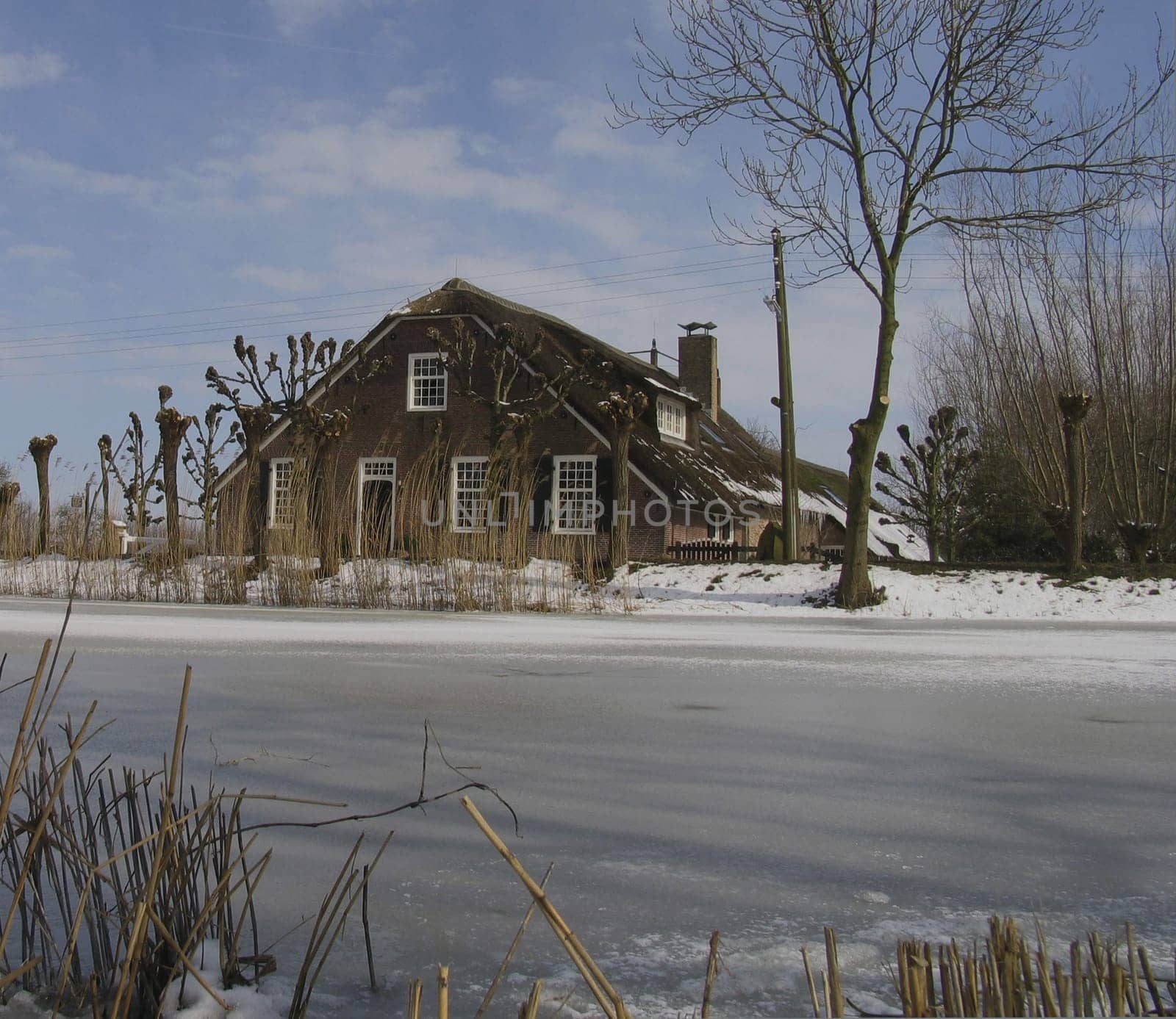 Old Dutch farm house in winter landscape