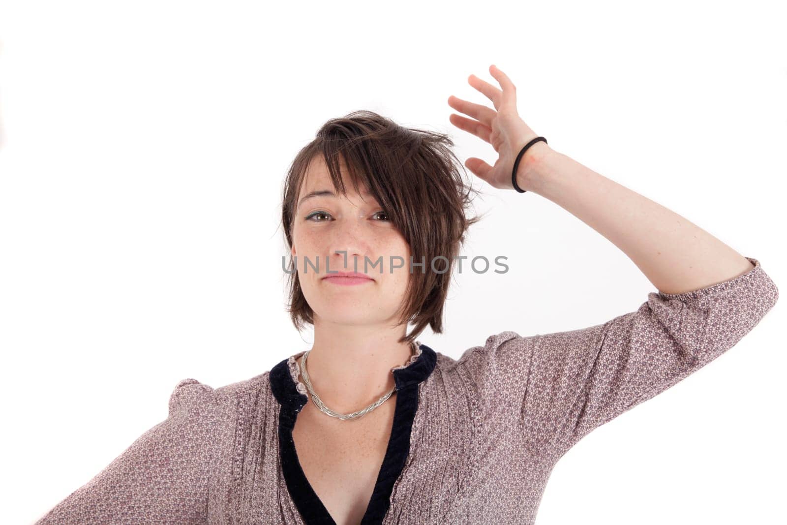 portrait of a young woman in grey dress playing with her hair on studio