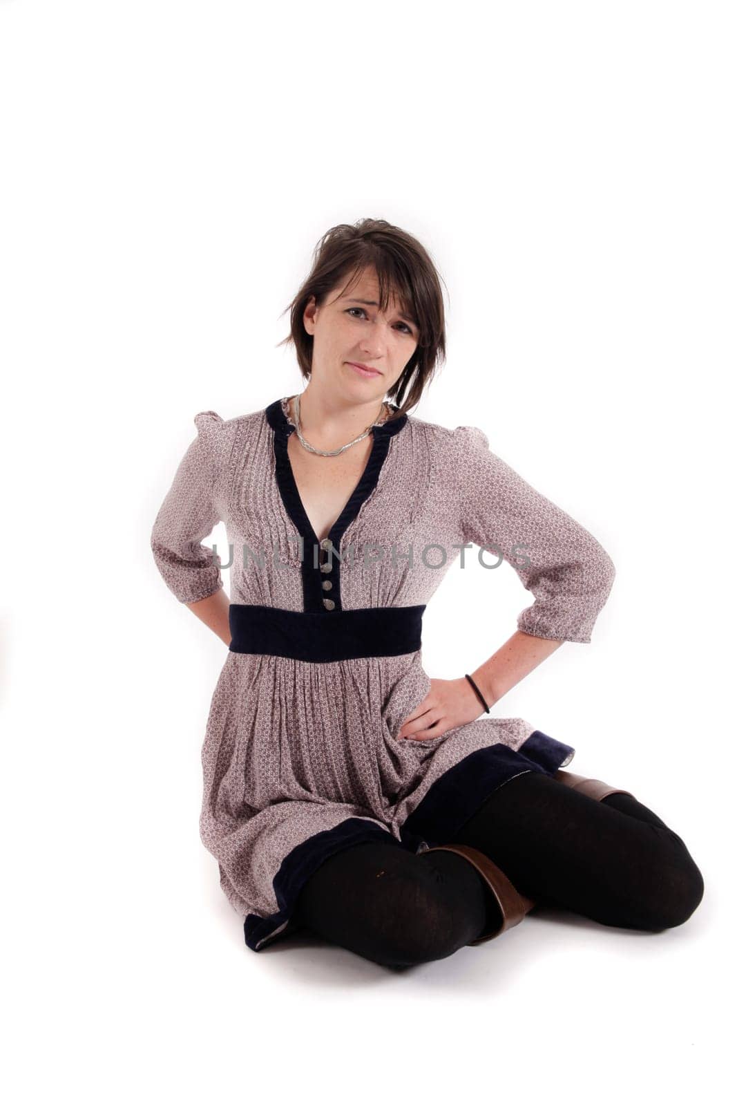 young brunette woman in dress sitting on the ground with boots