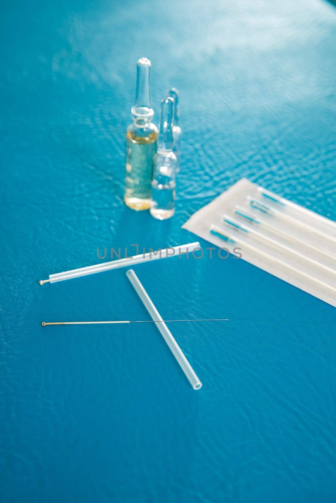 Acupuncture needles set and blister on blue leather background