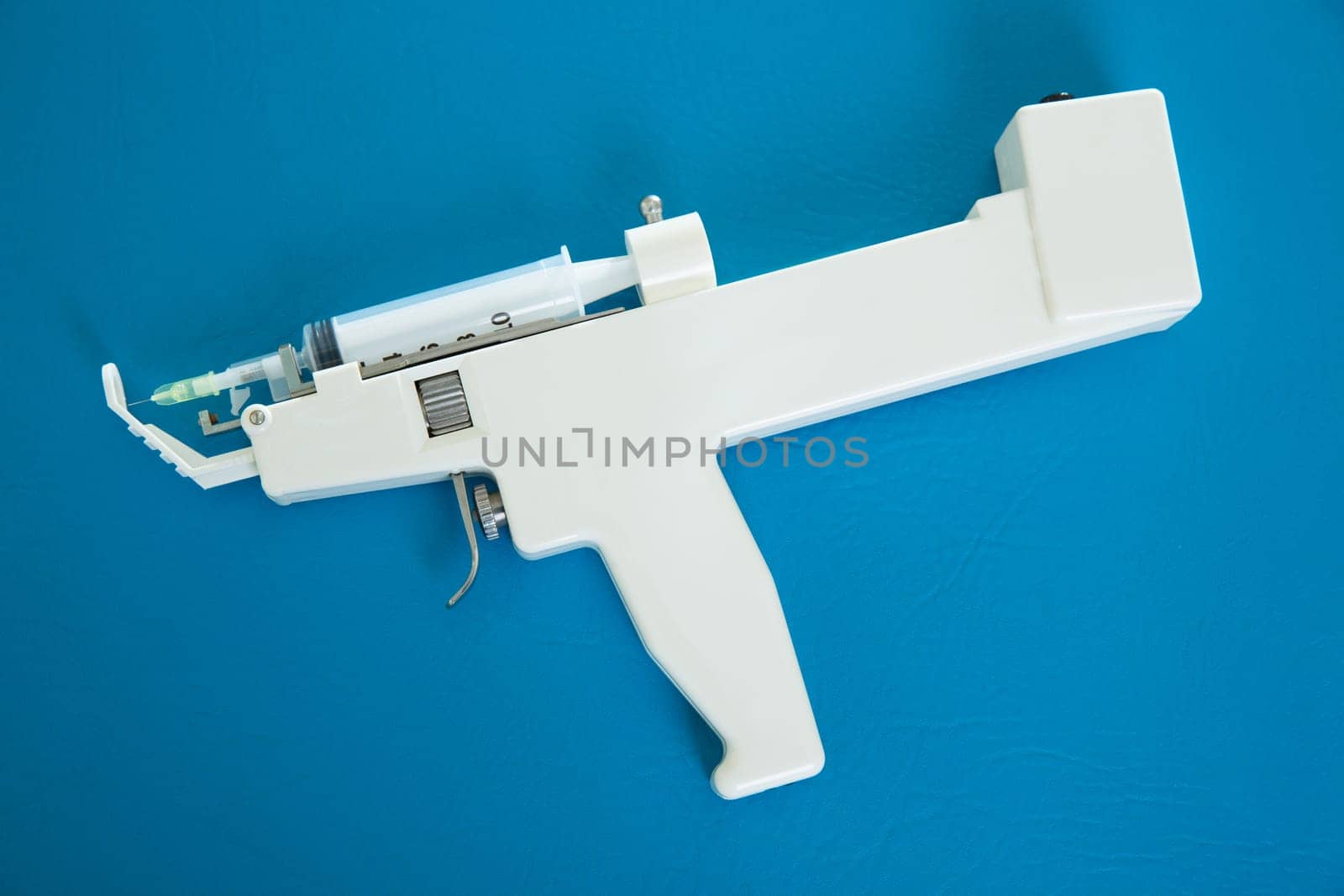 mesotherapy gun electronic with syringe on blue background