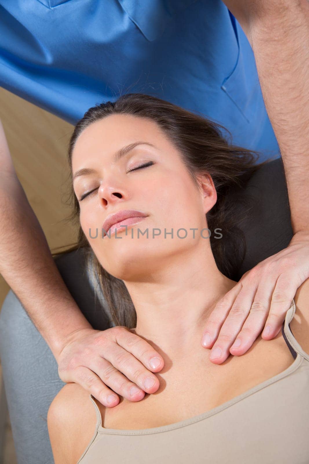 myofascial therapy on beautiful woman shoulders by therapist hands