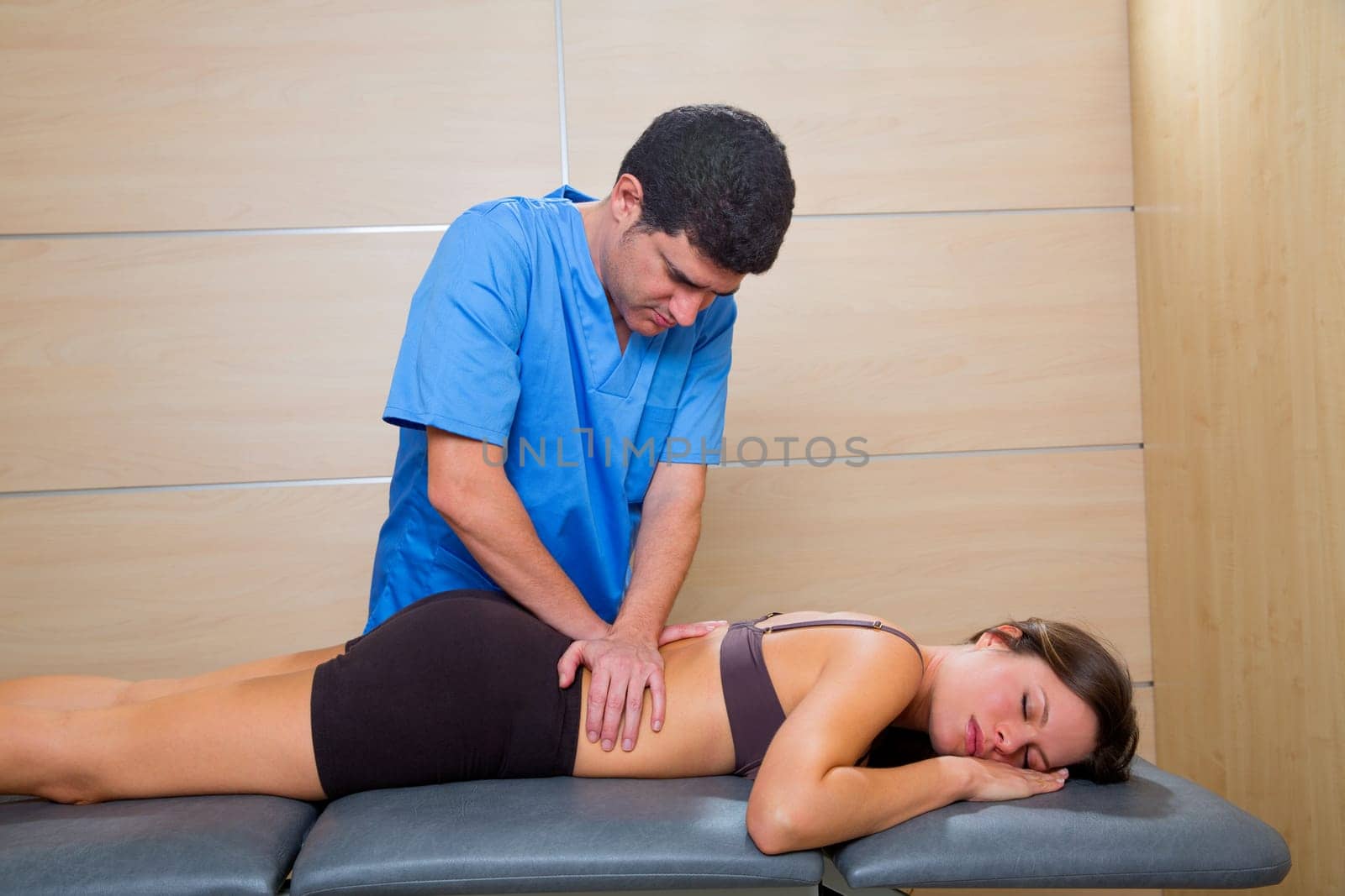 Massage therapy by physiotherapist on back torso to beautiful woman relaxed