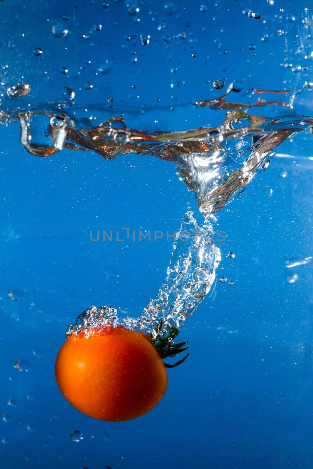 red tomato dropped into the water