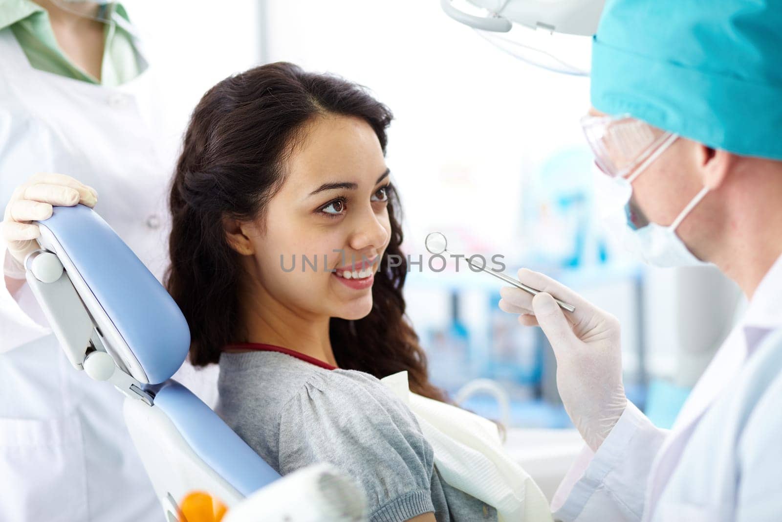 Pretty girl sitting at the dentists and having mouth checkup