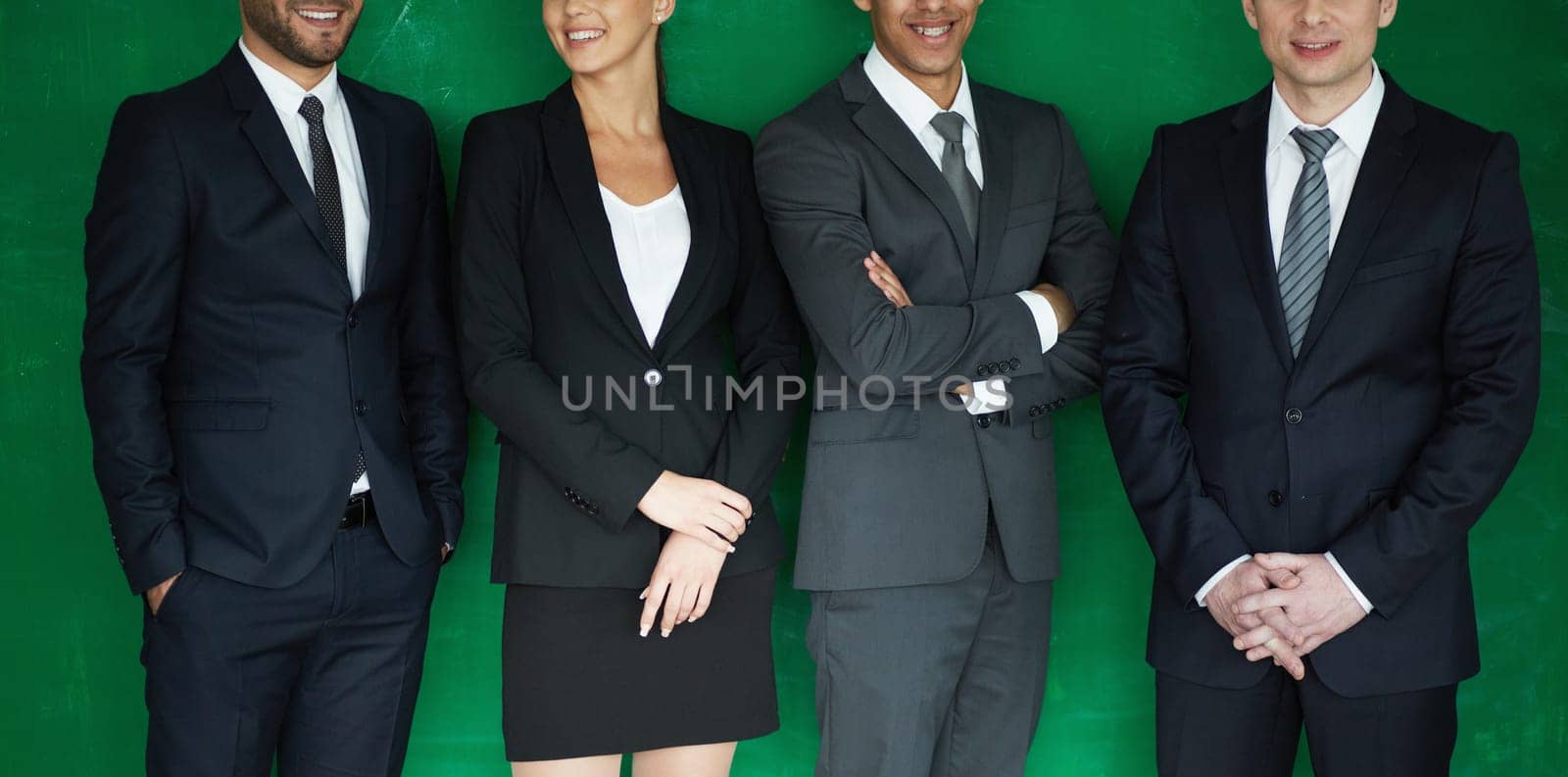 Four smiling business partners on green background