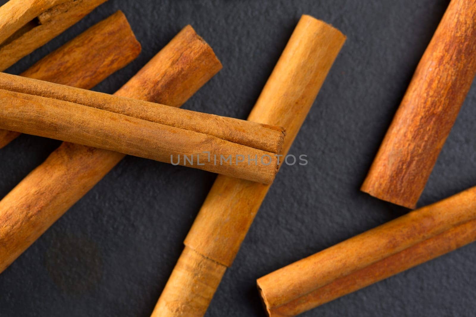 Cinnamon spice macro closeup detail on black slate stone background