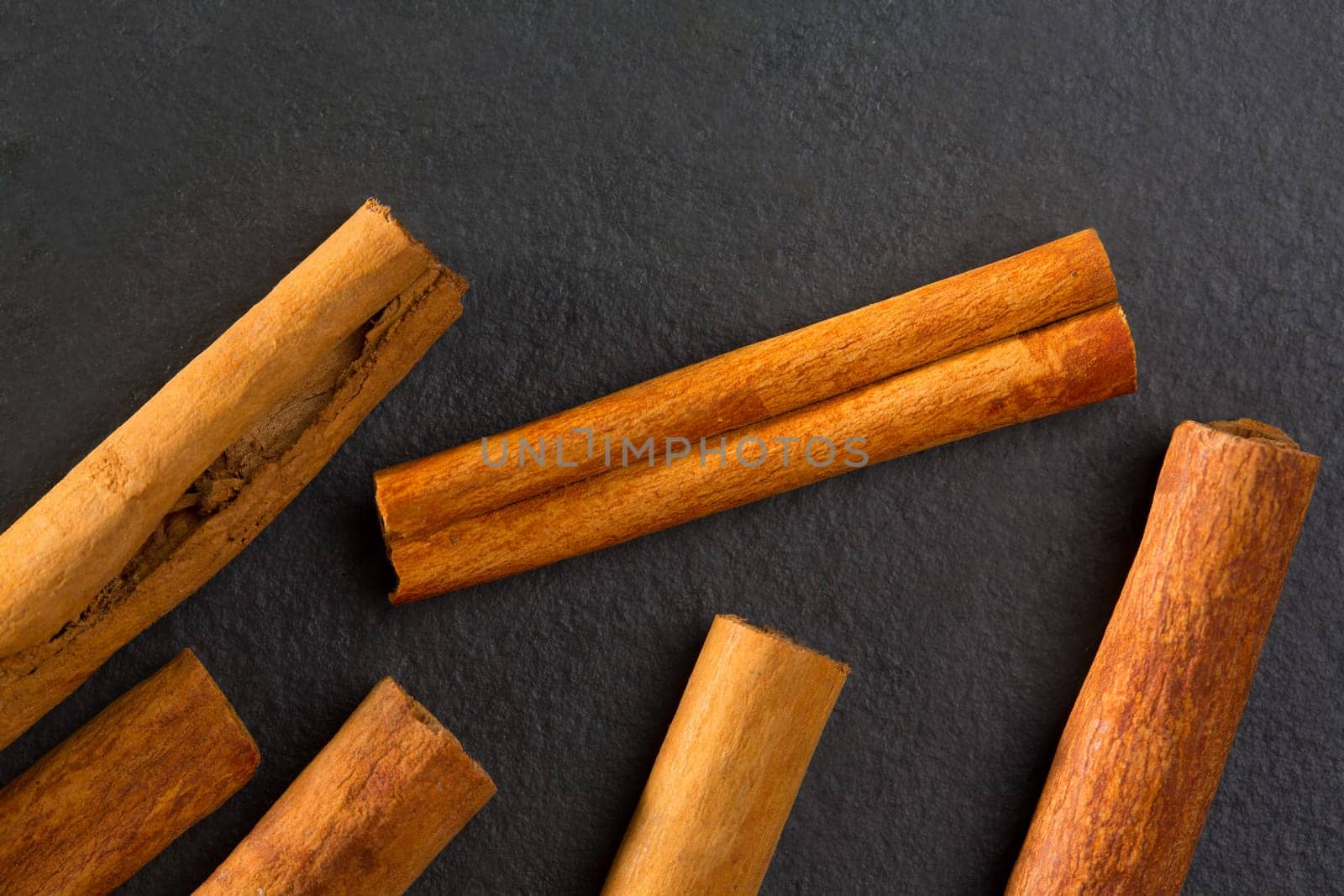Cinnamon spice macro closeup detail on black slate stone background