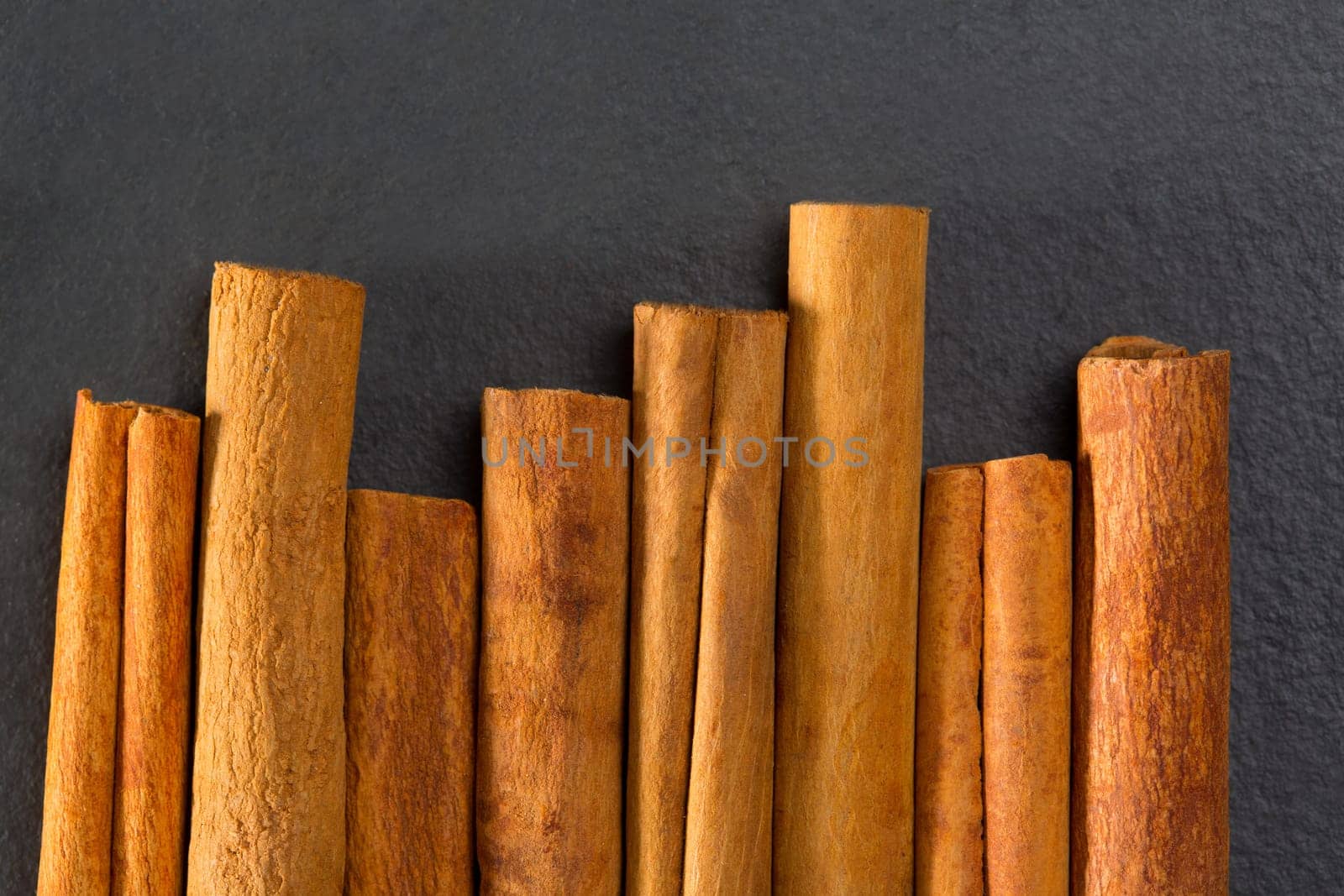 Cinnamon spice macro closeup detail on black slate stone background