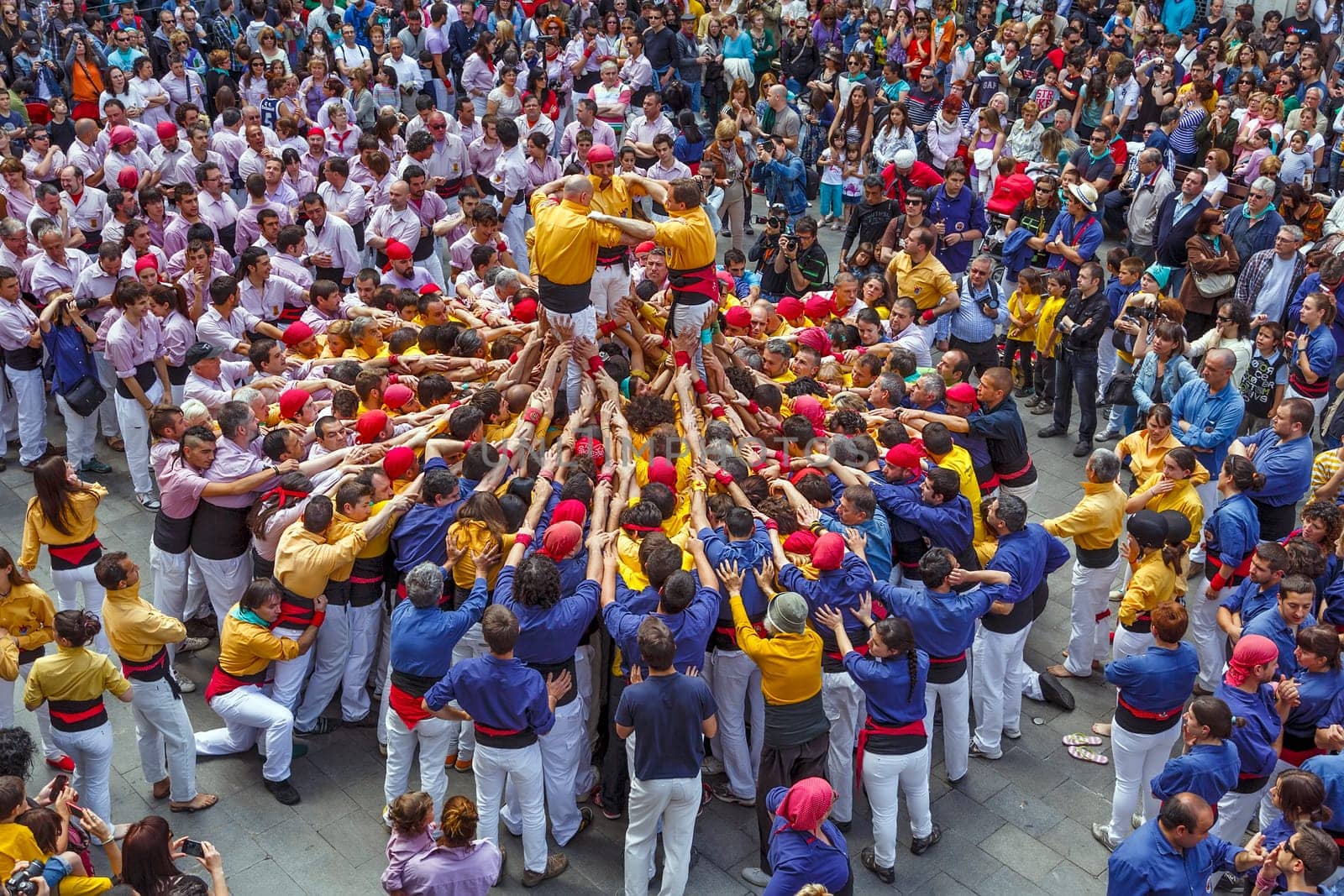 BARCELONA, SPAIN - MAY 19: Some unidentified people called Castellers do a Castell or Human Tower, typical tradition in Catalonia, on May 19, 2013 in Barcelona, Spain.