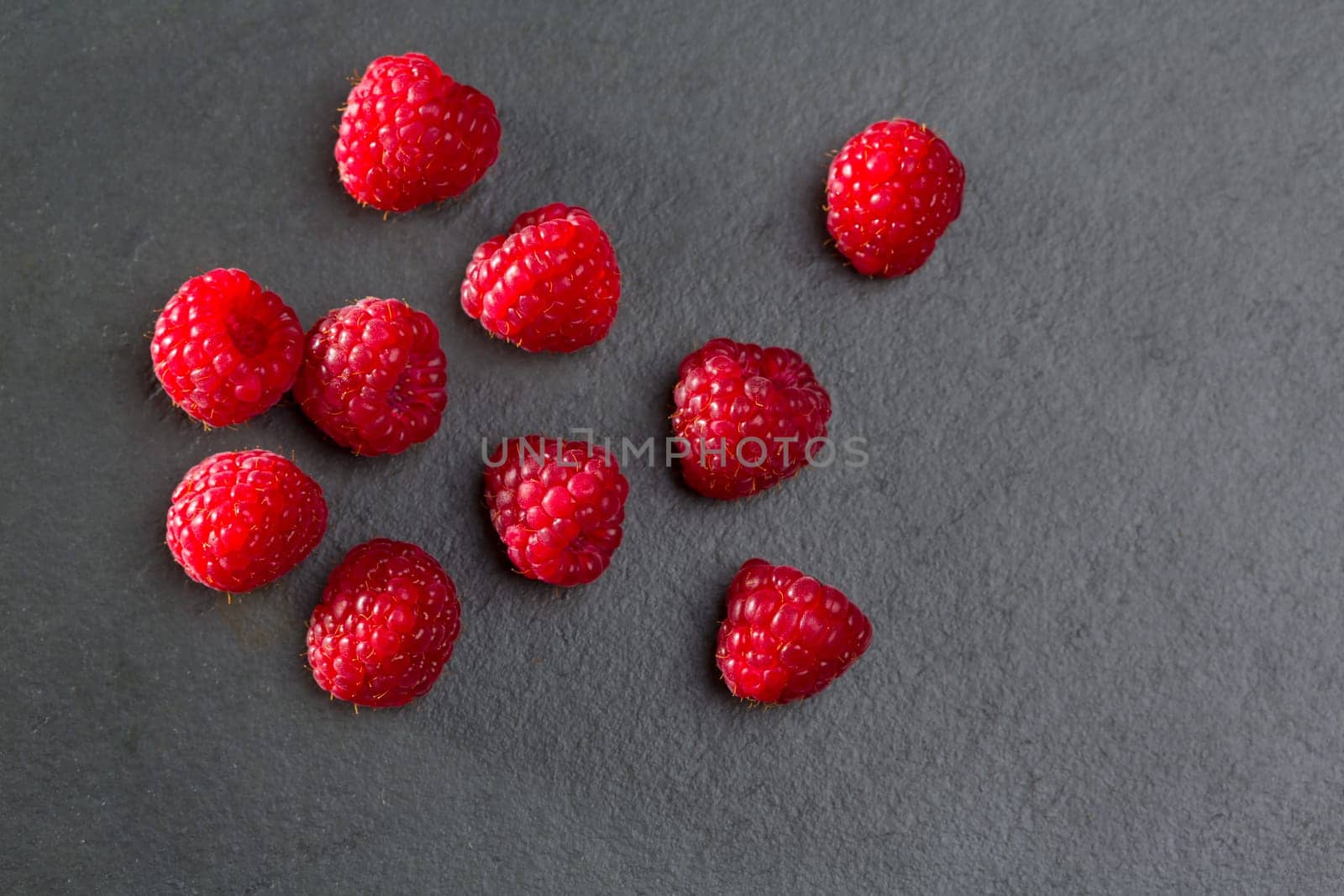 berries raspberry on black slate background macro closeup