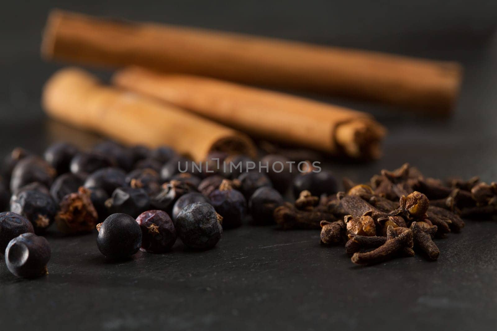 cloves cinnamon juniper berries Gyn tonic spices on black background