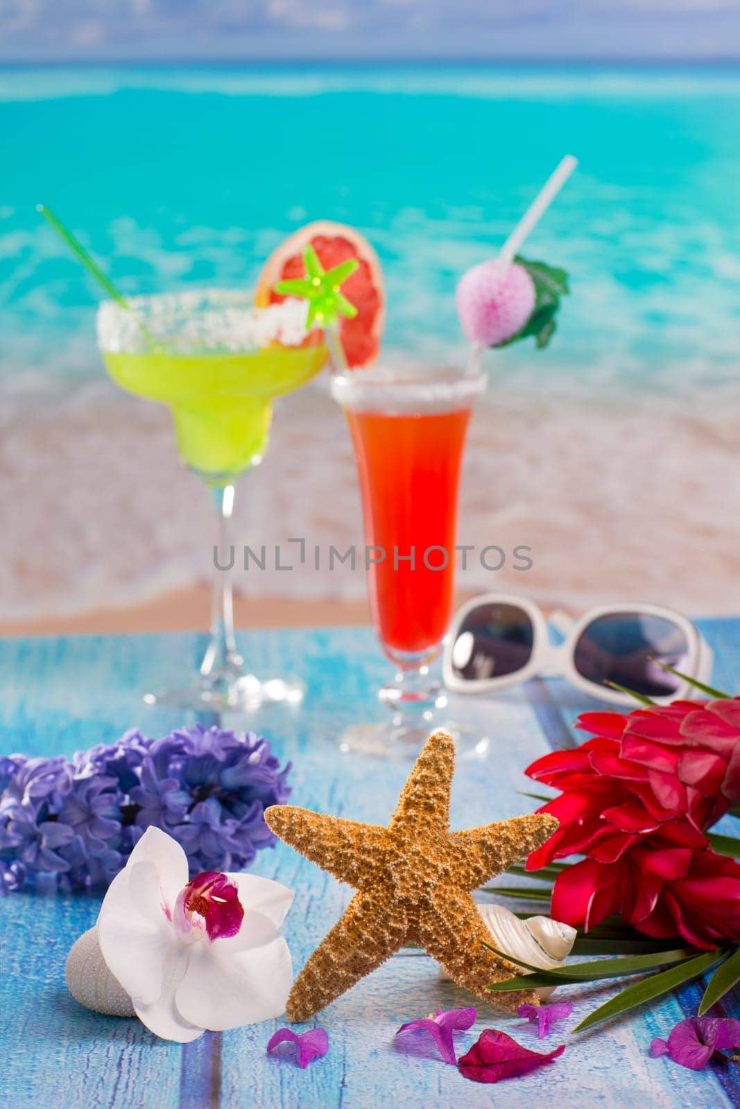 Cocktails margarita sex on the beach in colorful tropical house with flowers starfish and seashells