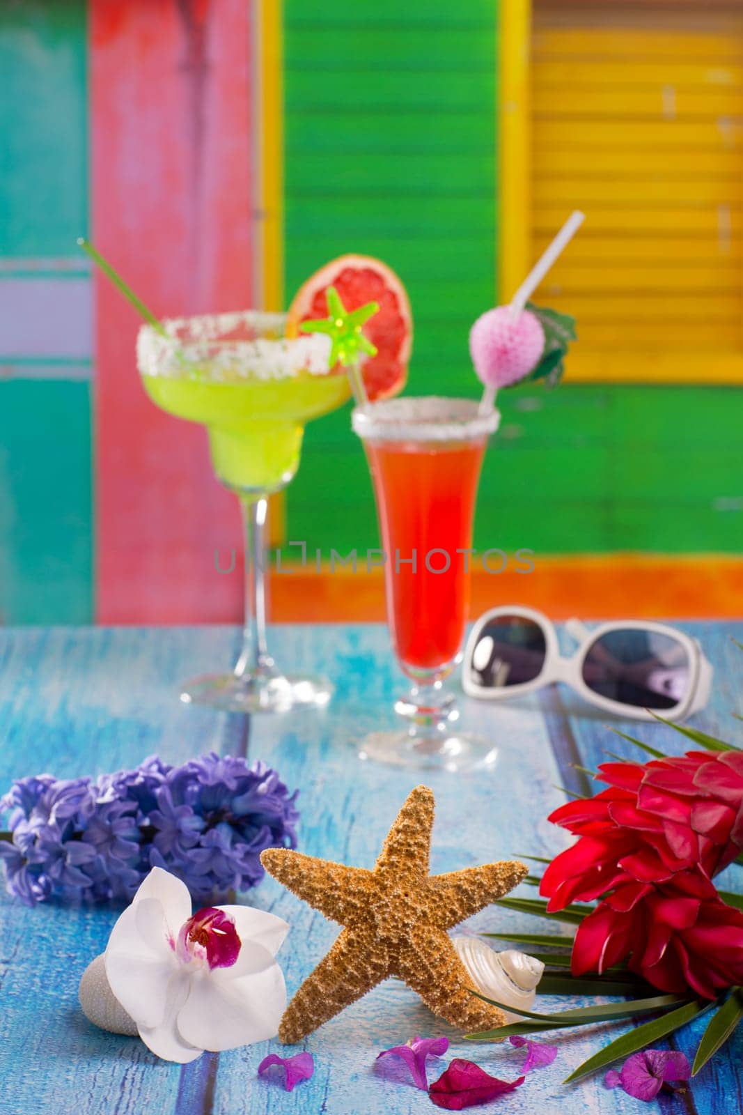 Cocktails margarita sex on the beach in colorful tropical house with starfish and sunglasses