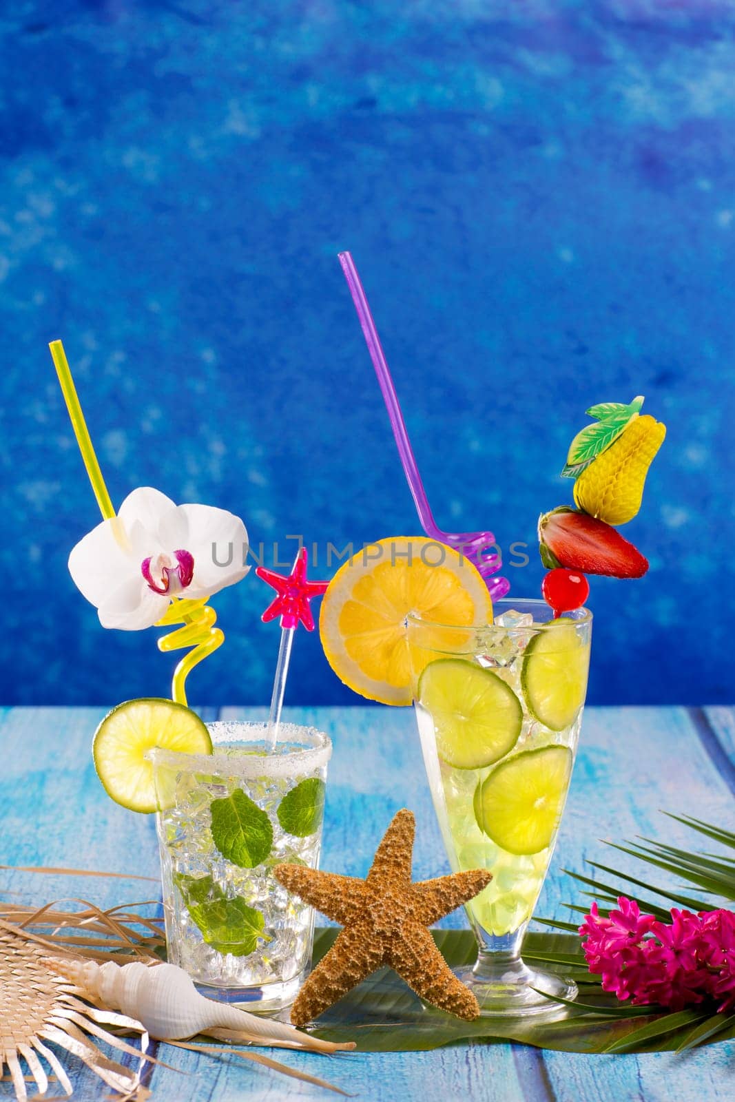 Mojito and lemon lime Cocktails in tropical Caribbean blue wood with starfish flowers and seashells
