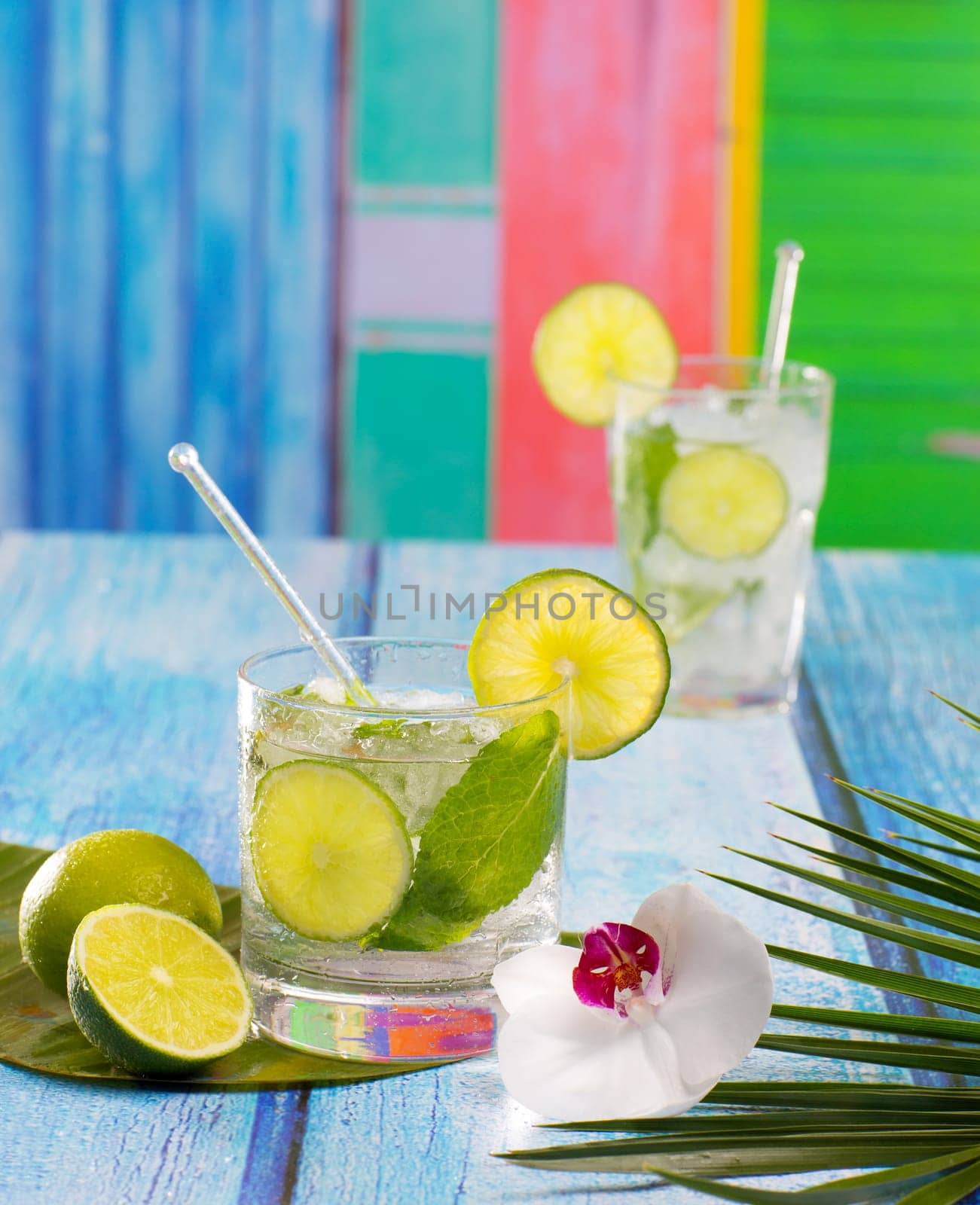 Cuban Mojito cocktail in tropical colorful house on blue wood with flowers and starfish