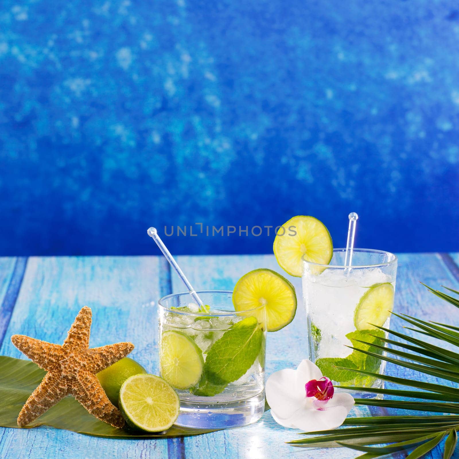 Cuban Mojito cocktail in tropical blue wood with flowers and starfish