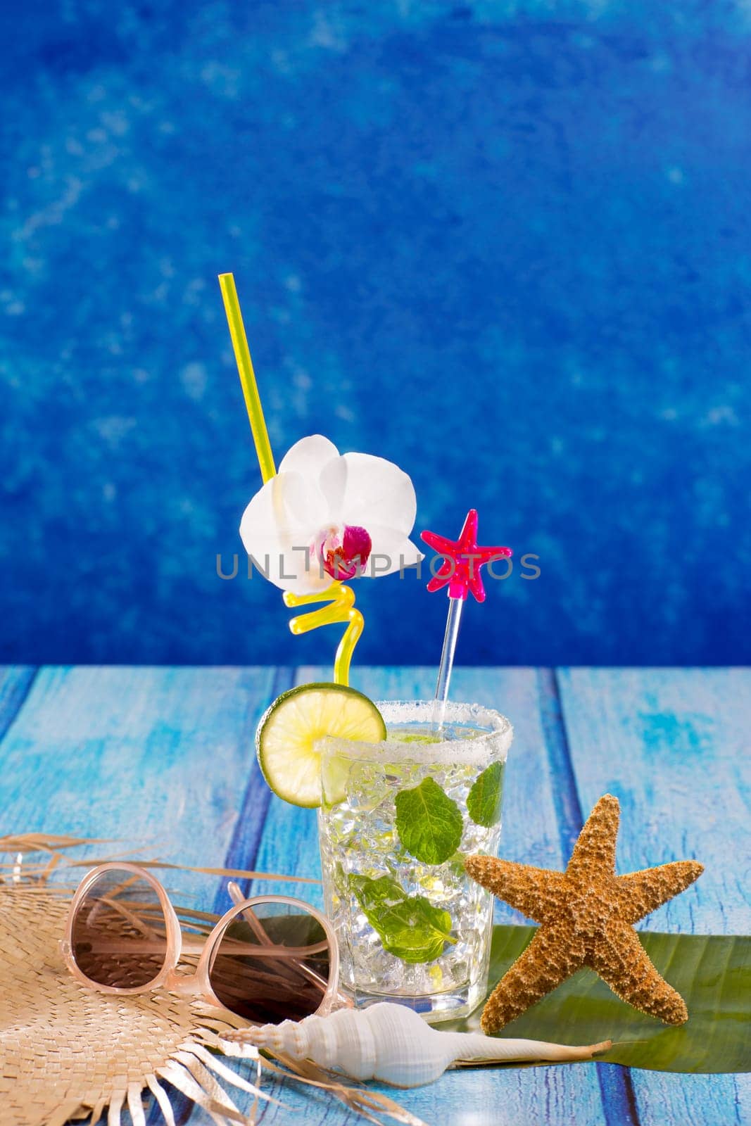 Cubn Mojito cocktail in Caribbean tropical blue wood with starfish and sunglasses