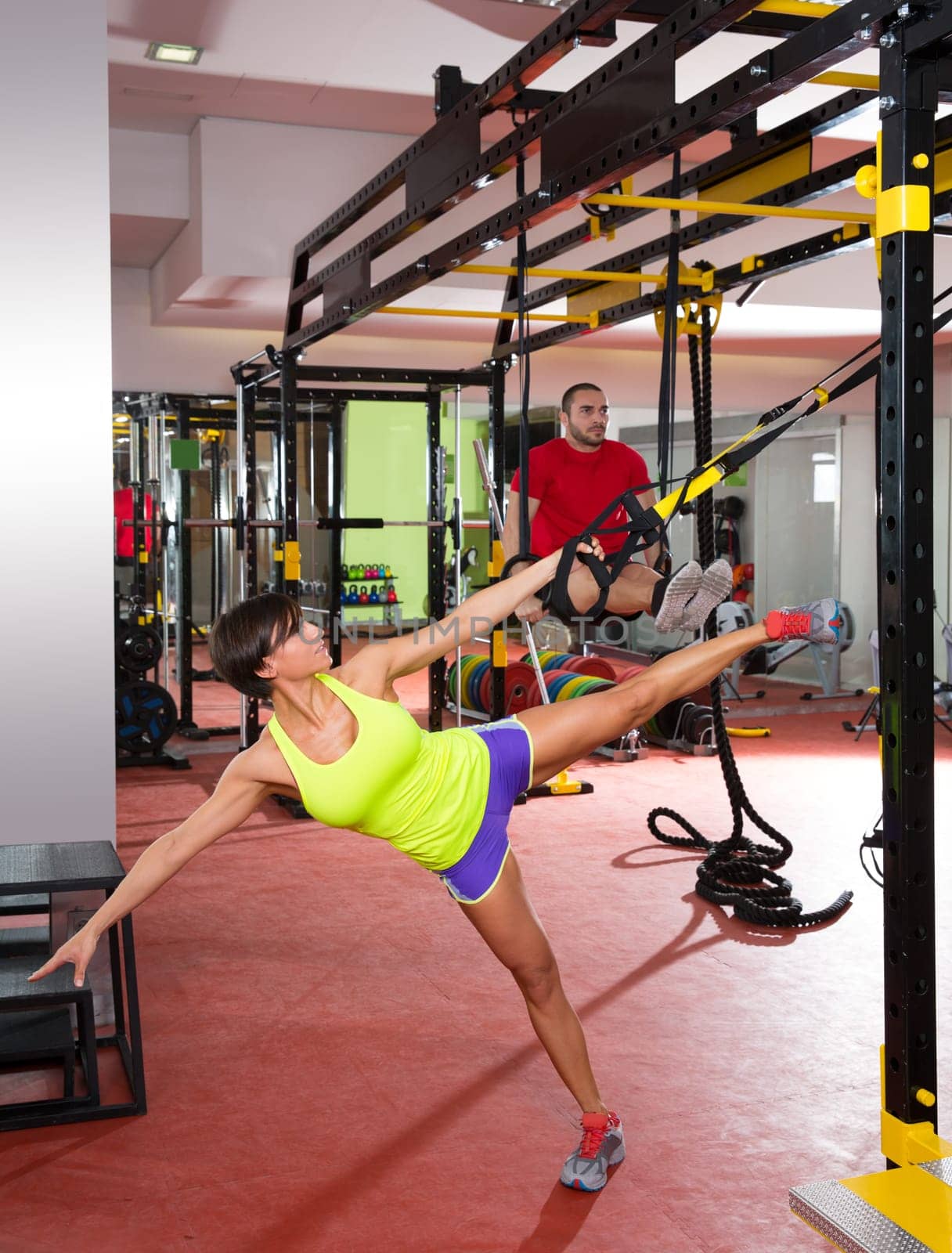 Crossfit fitness TRX training exercises at gym woman and dip rings man workout