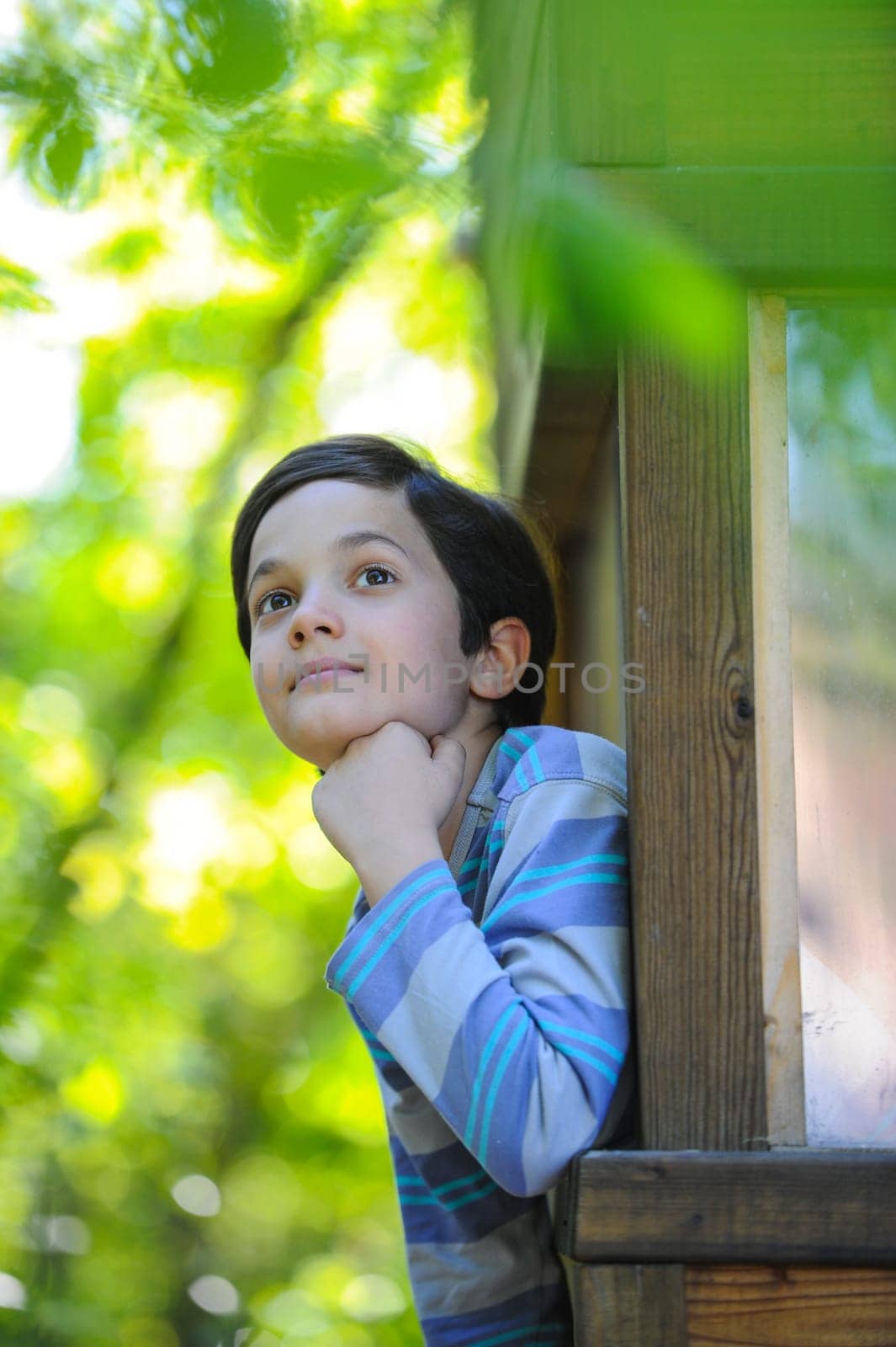 Enfant observant la nature dans sa cabane