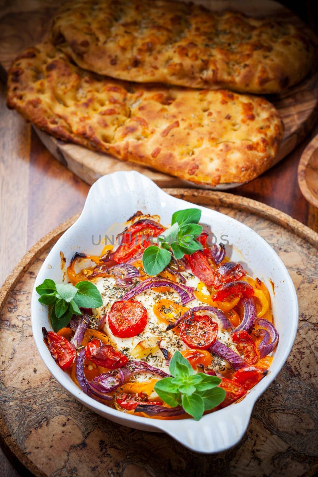 Baked feta cheese on vegetables and olive bread