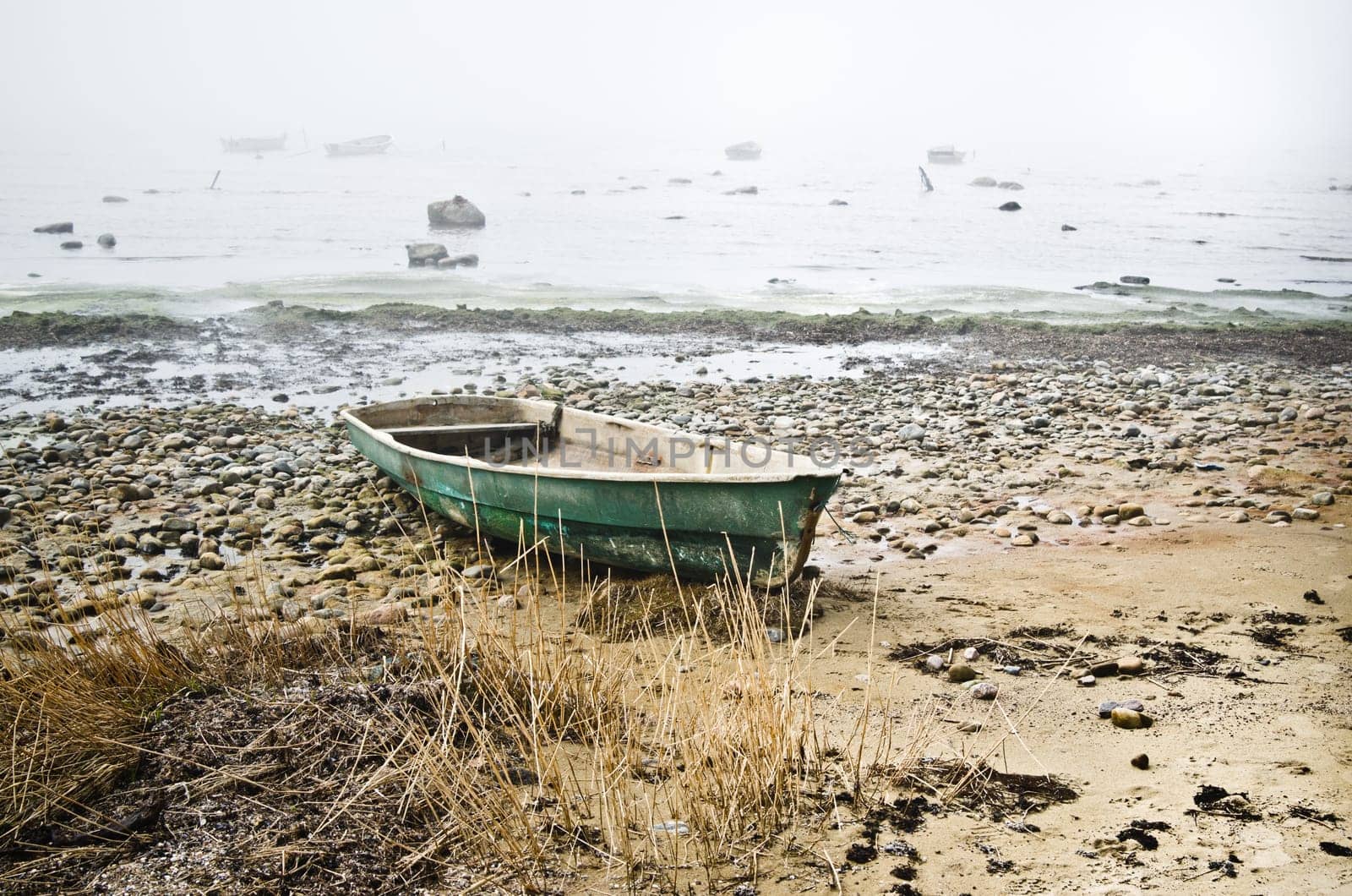 Old fishing boat at coast foggy in the morning