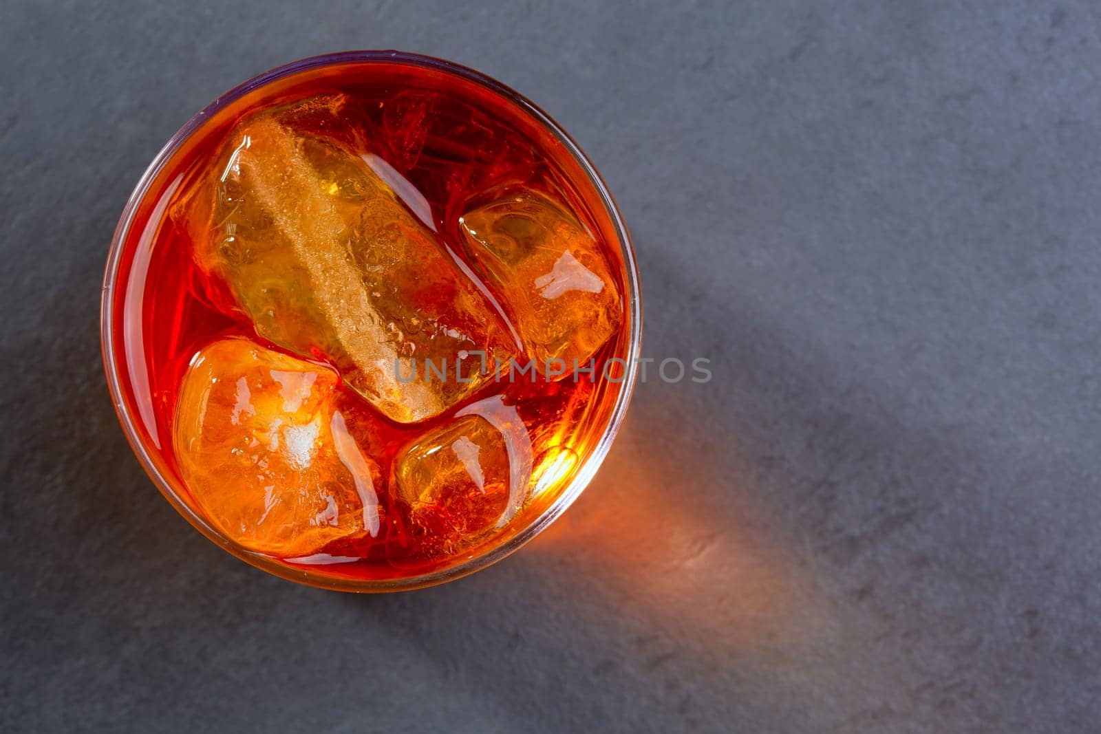 Whiskey whisky on the rocks on glass over gray black background