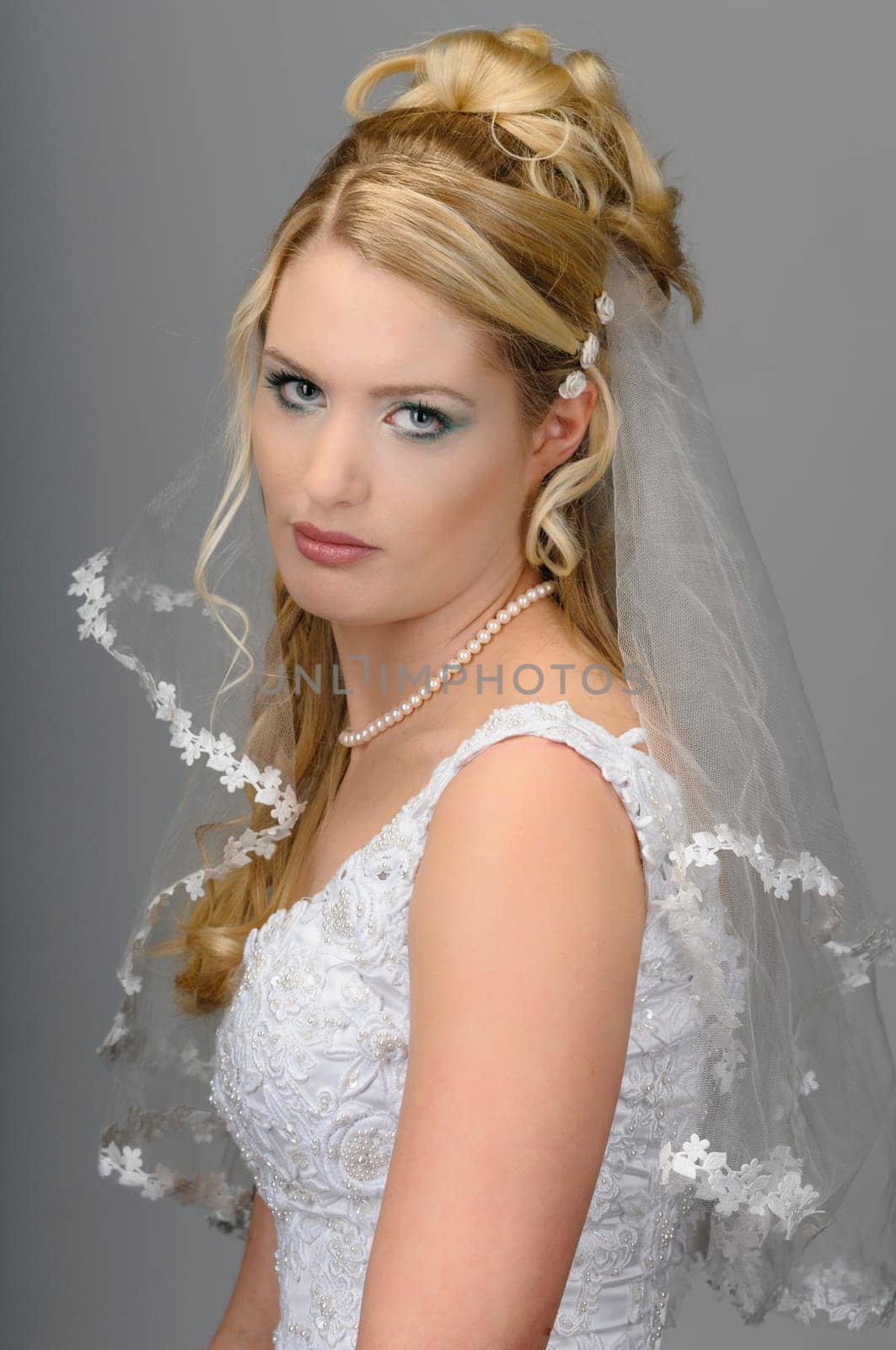 Portrait of a young bride with high hair und white bride dress.