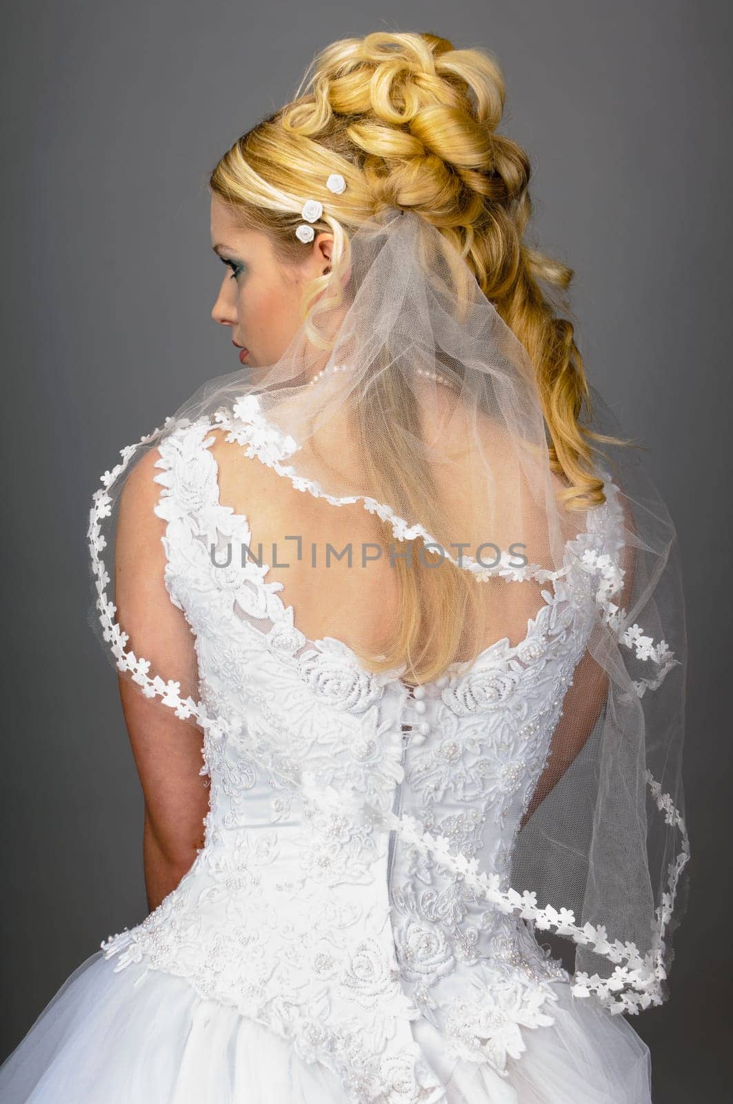 Portrait of a young bride with high hair und white bride dress.