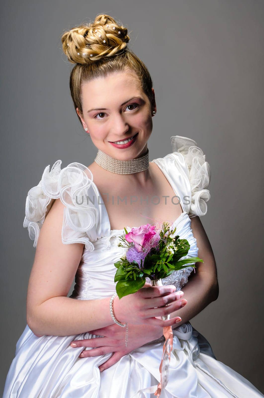 Portrait of a young bride with high hair und white bride dress.