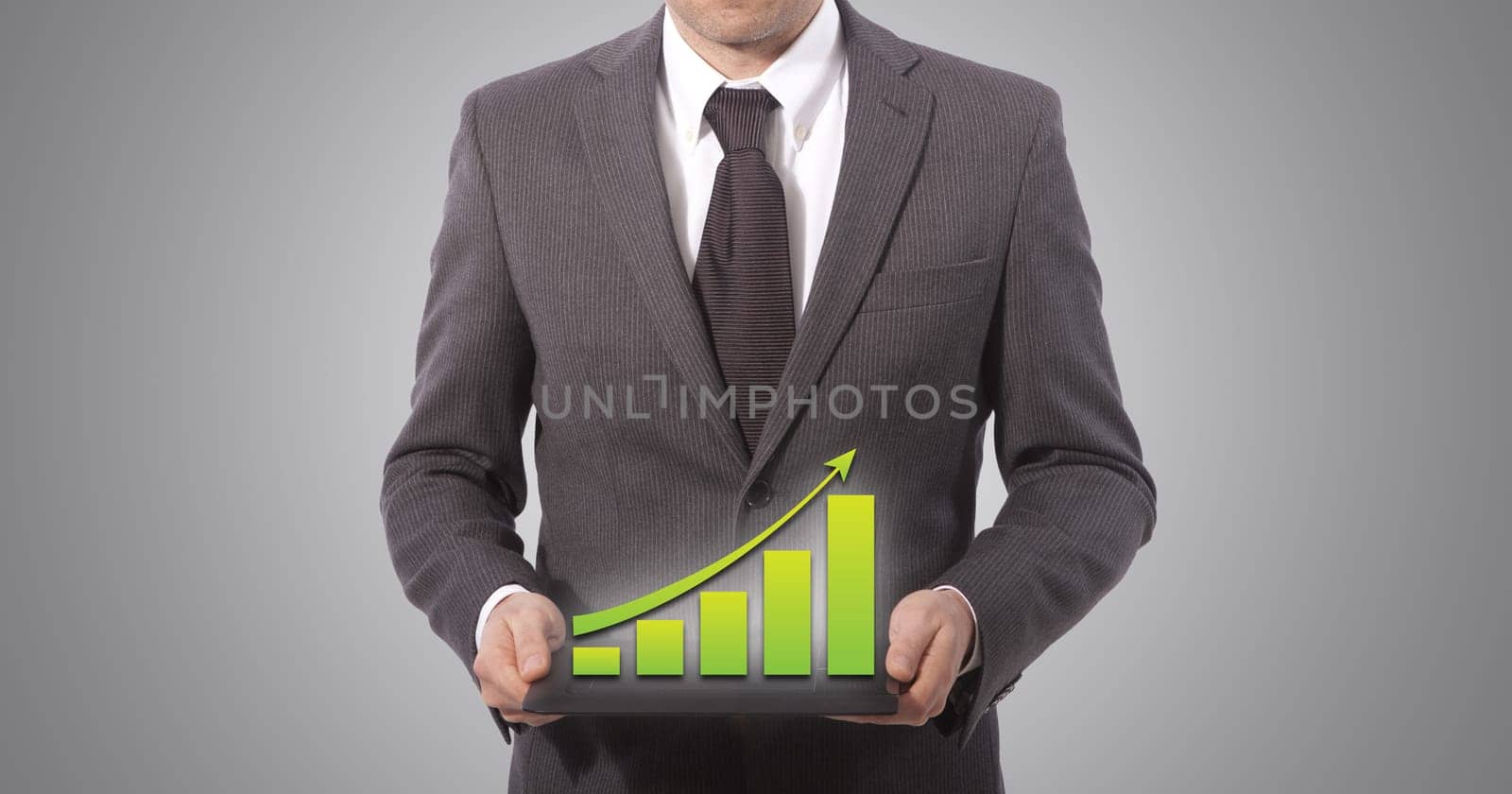 business man with touch screen graph on a tablet, grey background.