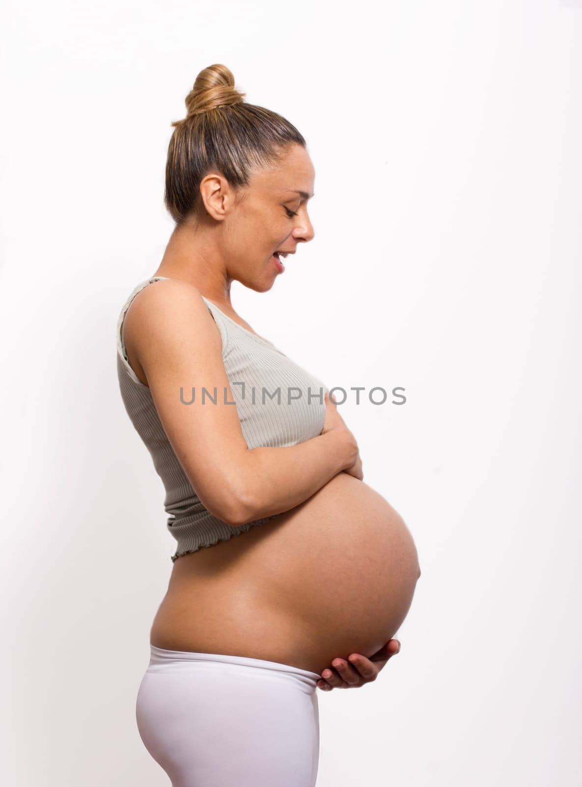 pregnant woman holding and watch her belly