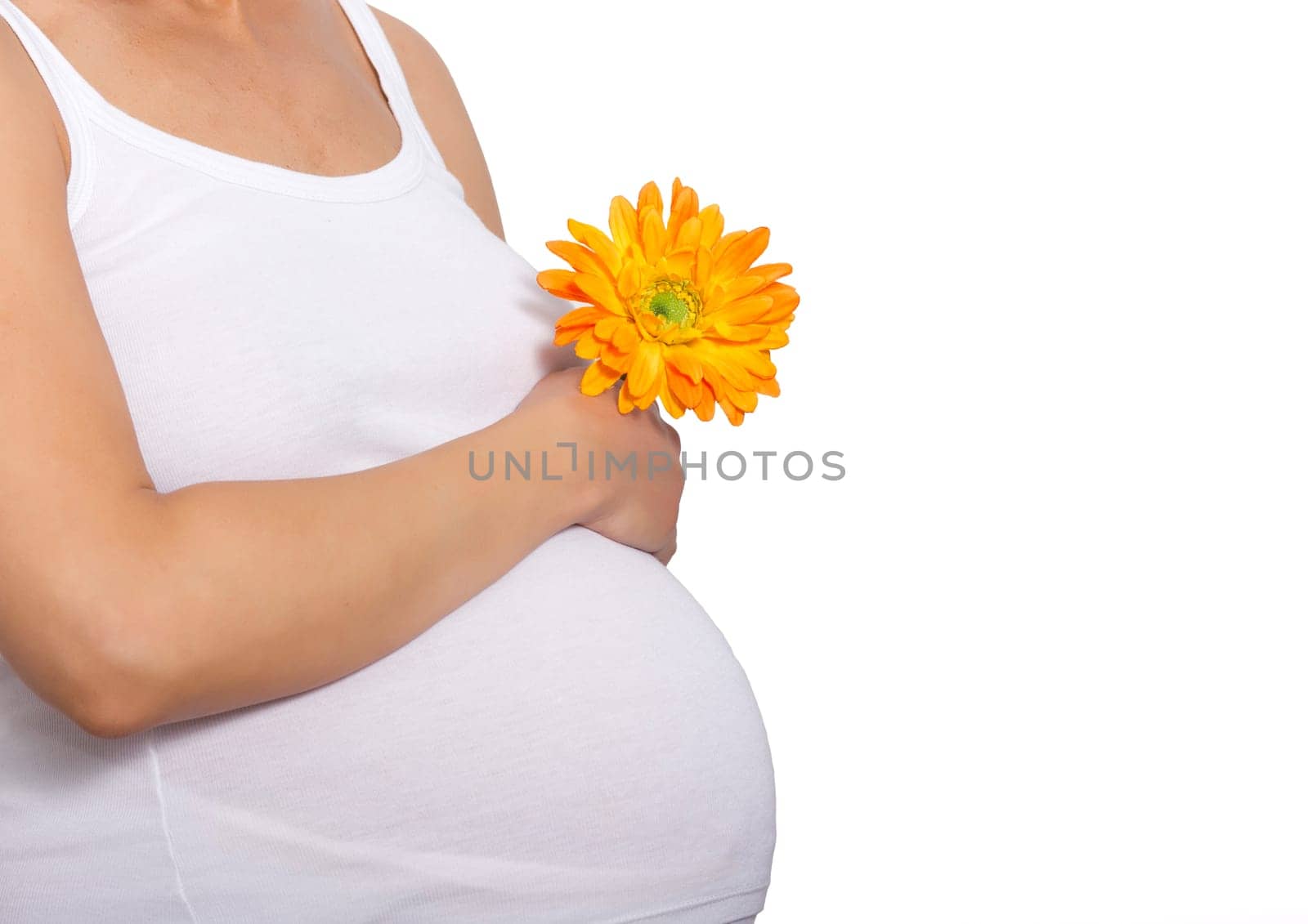 Pregnant woman touching here belly and holding a flower