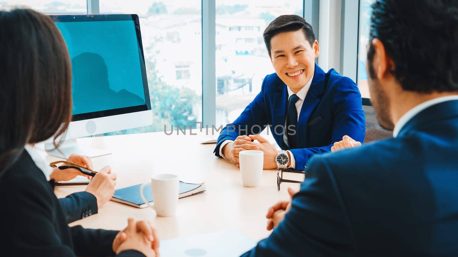 Business people in the conference room with green screen chroma key TV or computer on the office table. Diverse group of businessman and businesswoman in meeting on video conference call . Jivy