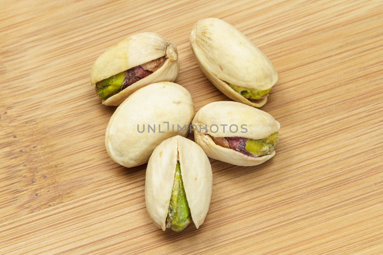 Pistachio nuts on wooden board