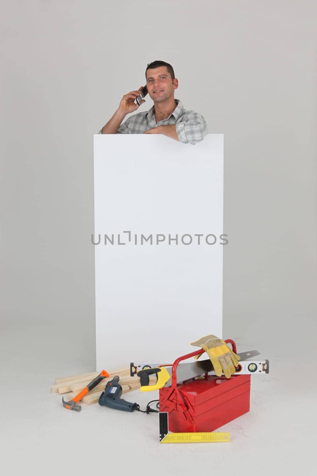 Carpenter stood by advertising whilst making a call