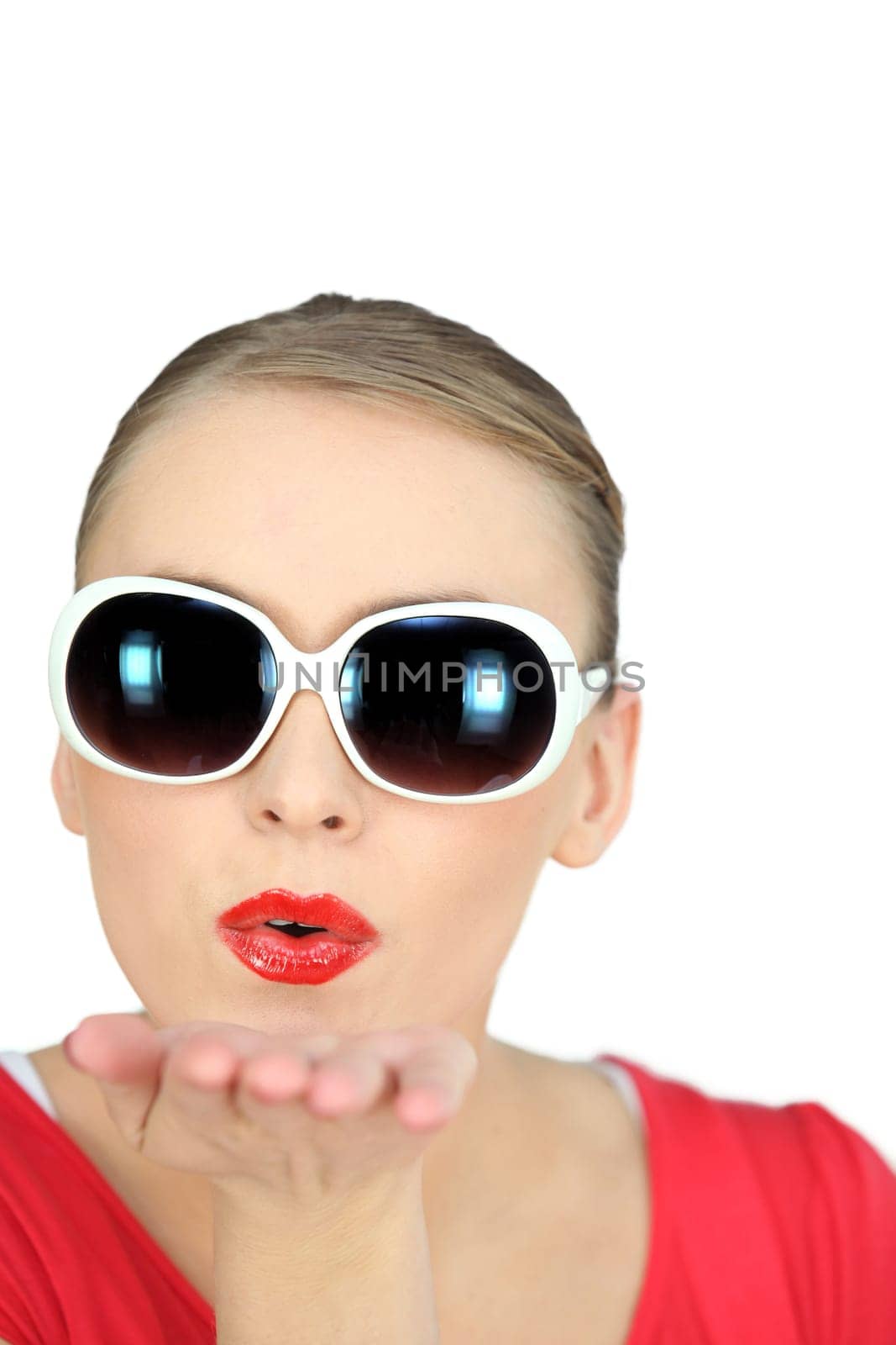 Woman with sunglasses blowing kisses on white background
