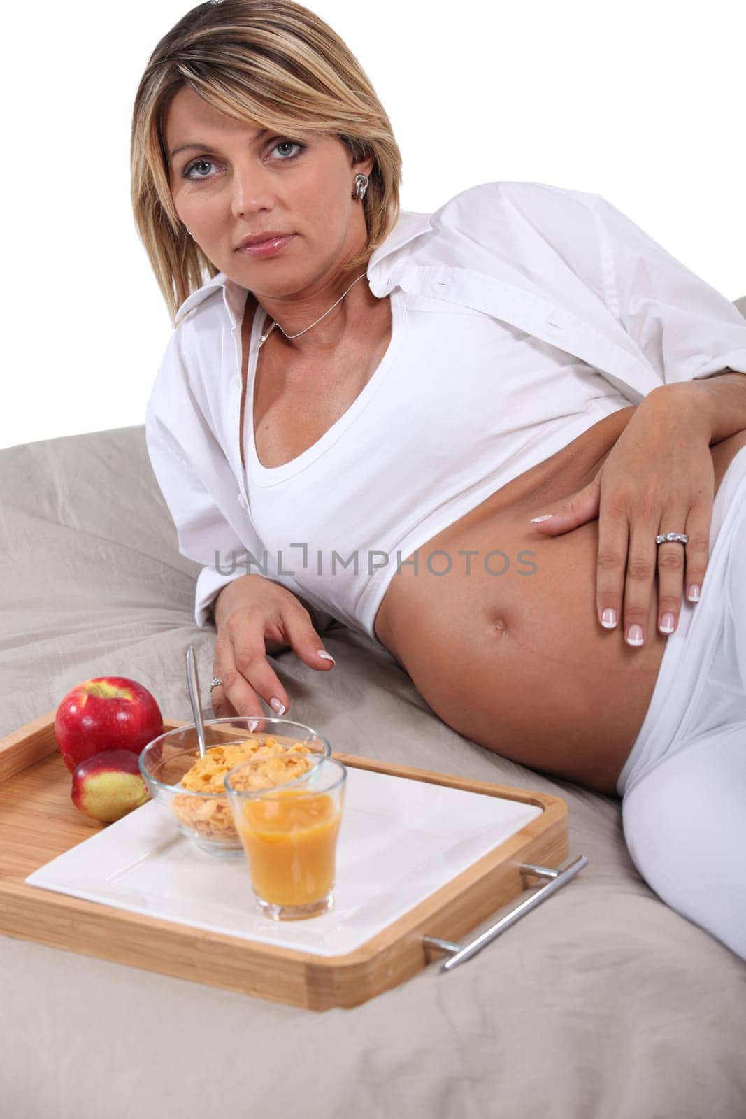 Pregnant woman having breakfast in bed