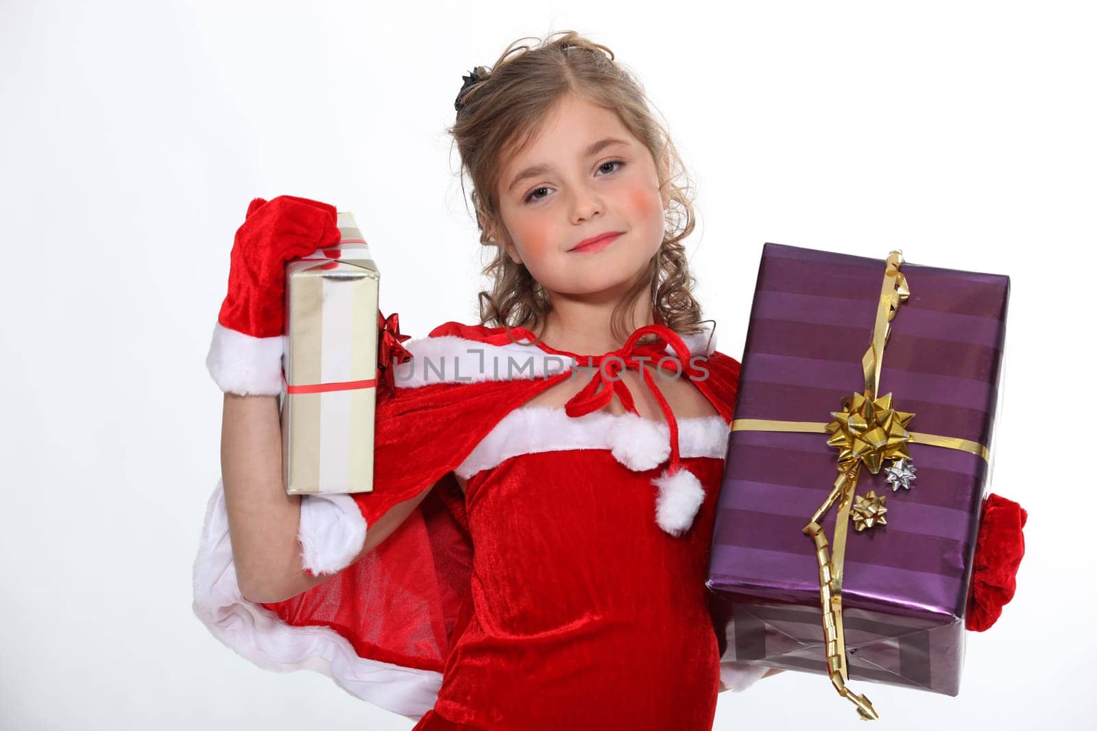 Little girl dressed in festive outfit carrying presents
