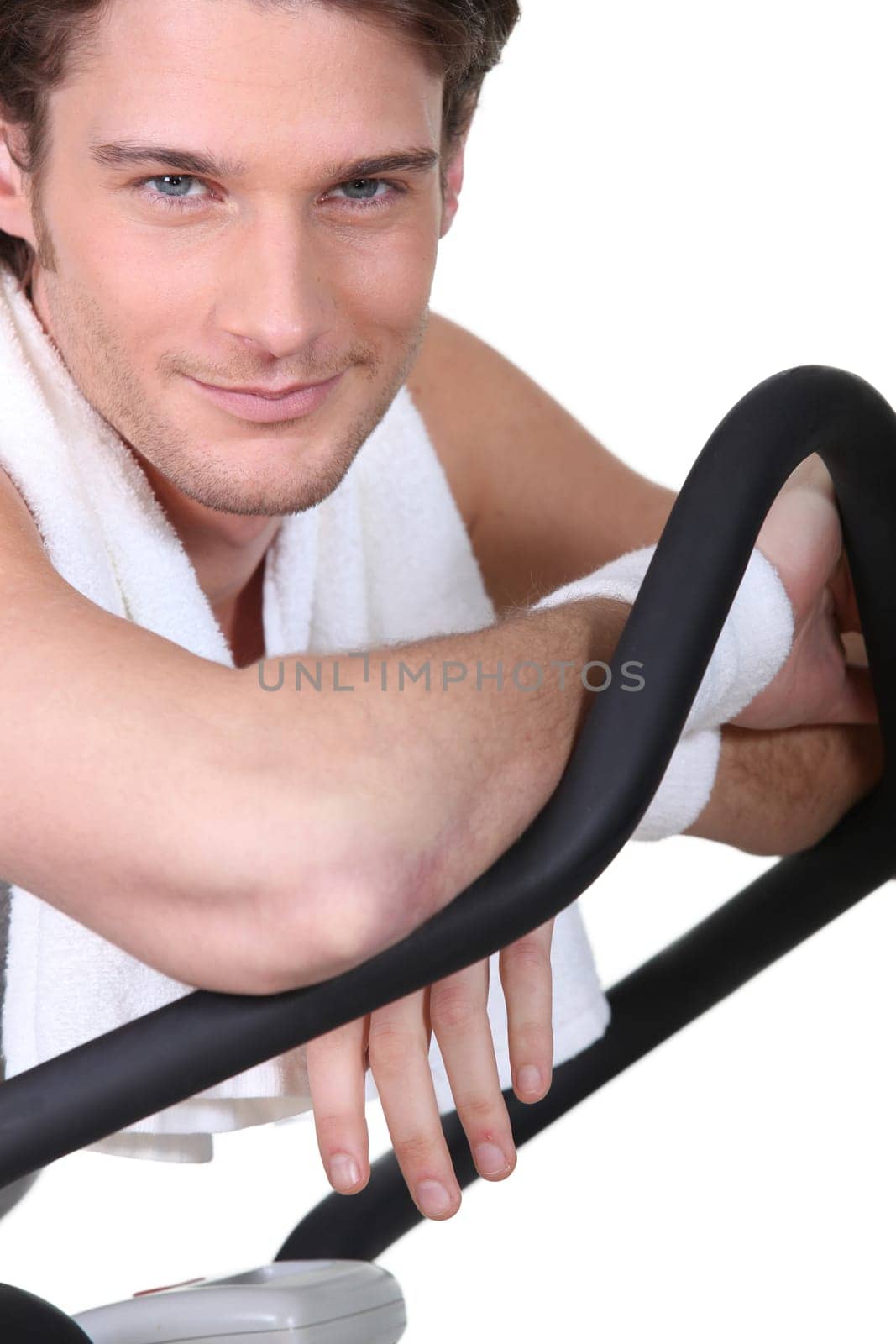 Smiling man sitting on cross trainer
