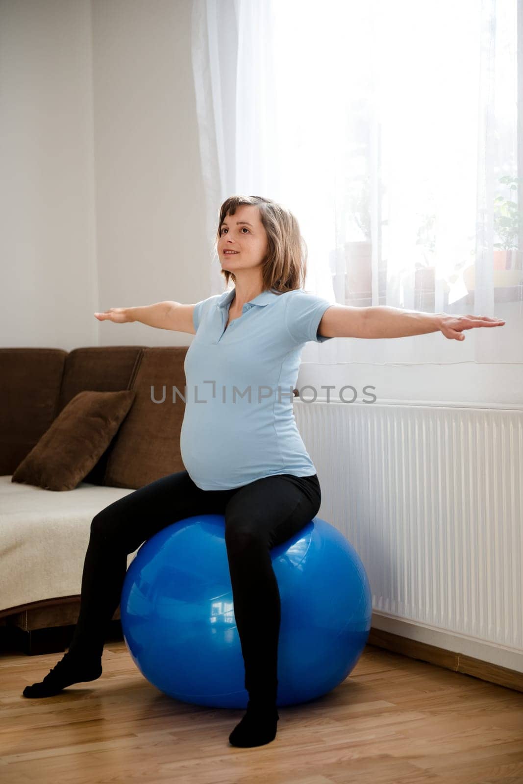 Pregnant woman exercising with fit ball at home
